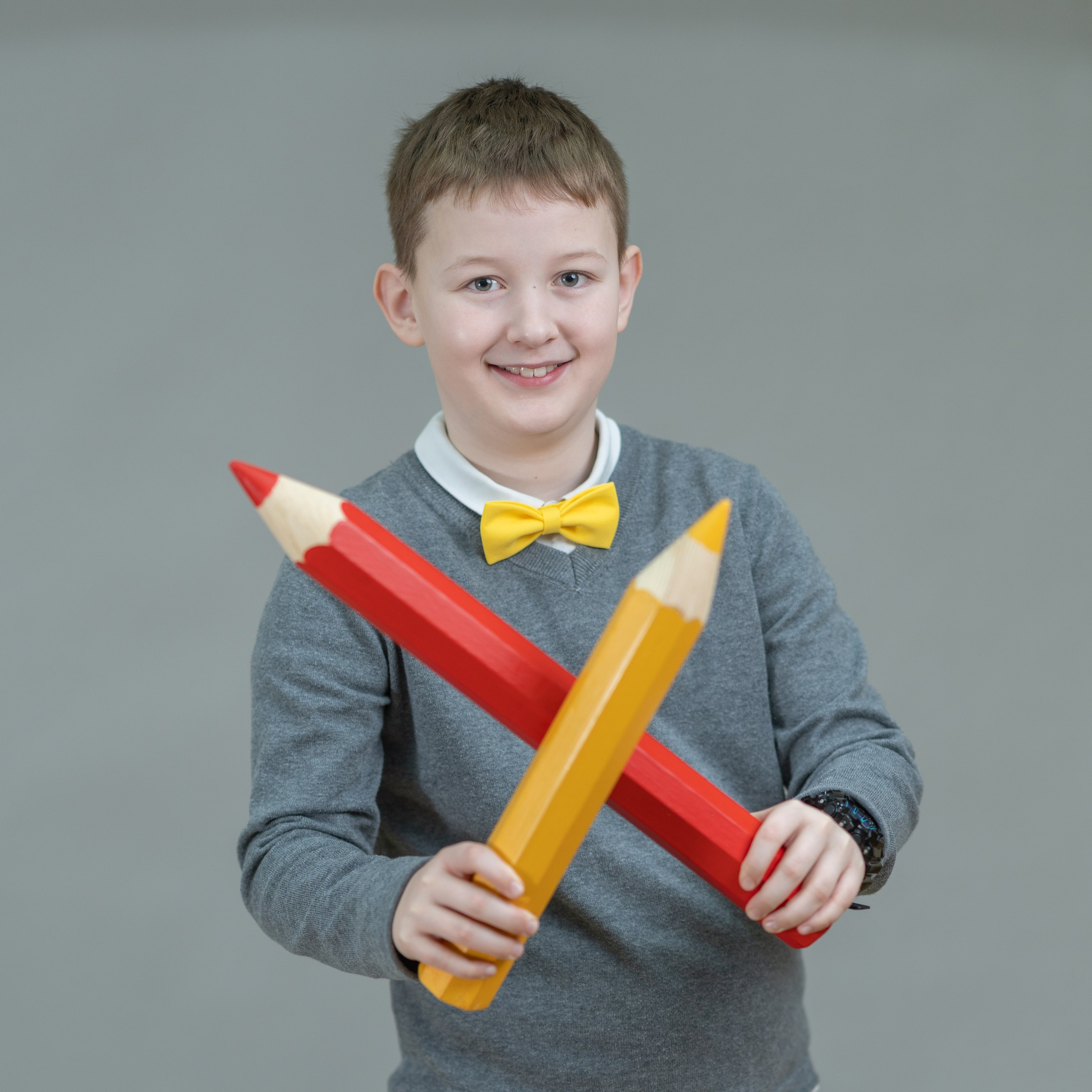 Мальчик с гигантскими карандашами. Школьная съемка на сером фоне. Школьный  фотограф в Москве Первенцева Елена.