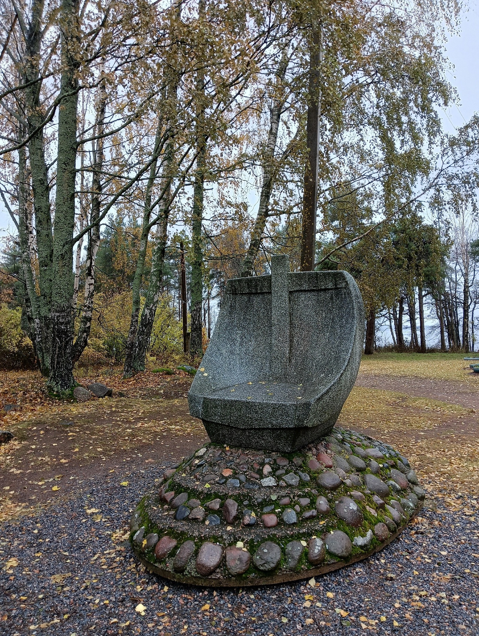 Каменный памятник на осенней остановке маршрута