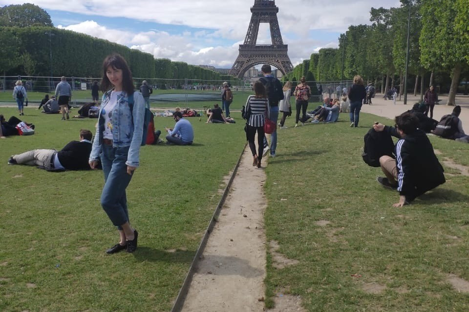 Путешествие в париж, девушка стоит перед эйфелевой башней