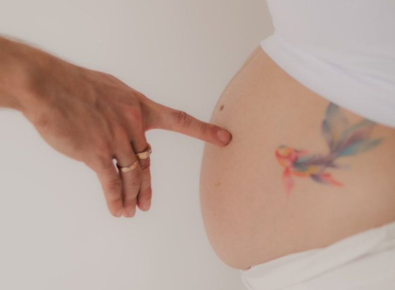 фотограф беременности проводит студийную съемку с мягким светом