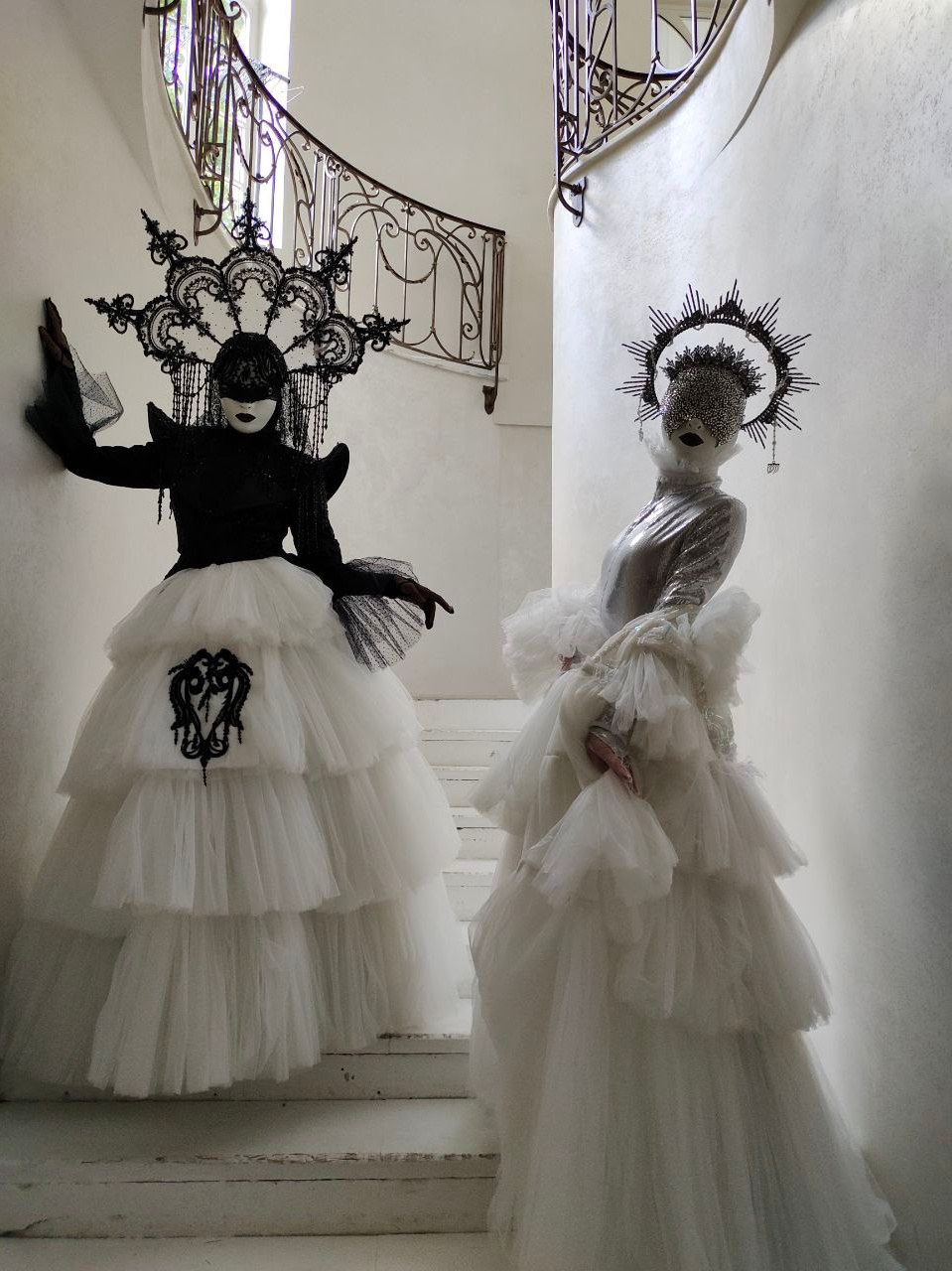 Два пеших артиста в серебряном и чёрно-белом платье встречают гостей на лестнице Вилла Ротонда