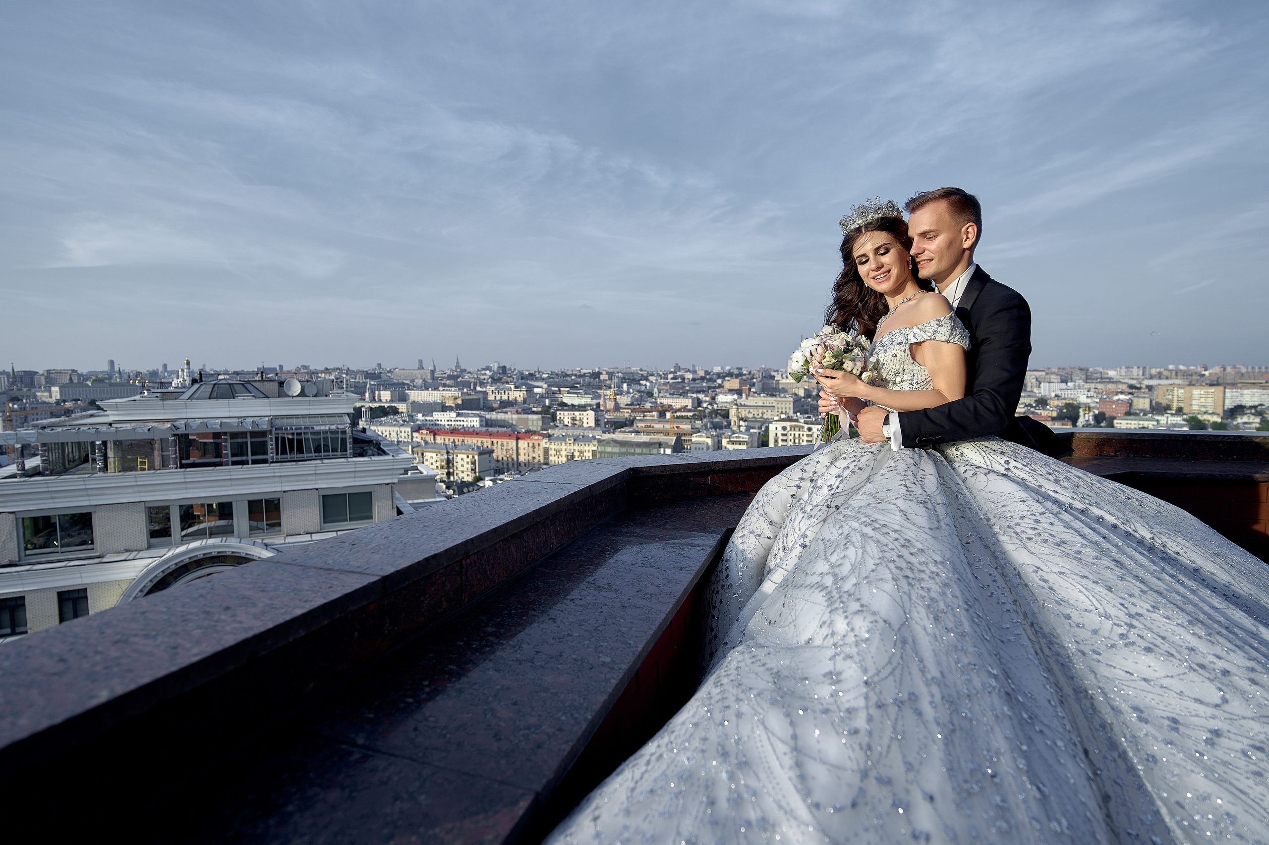 Молодожены обнявшись смотрят сверху на город. Свадебный фотограф Сергей Гаварос. Свадебная фотосъемка в Москве