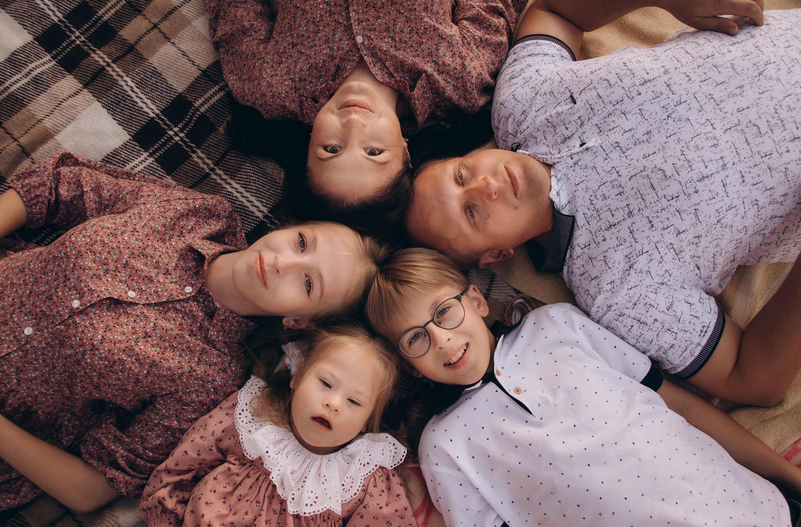 Семья: родители и двое детей, один из которых -  новорождённый, сняты в привычной обстановке собственного дома