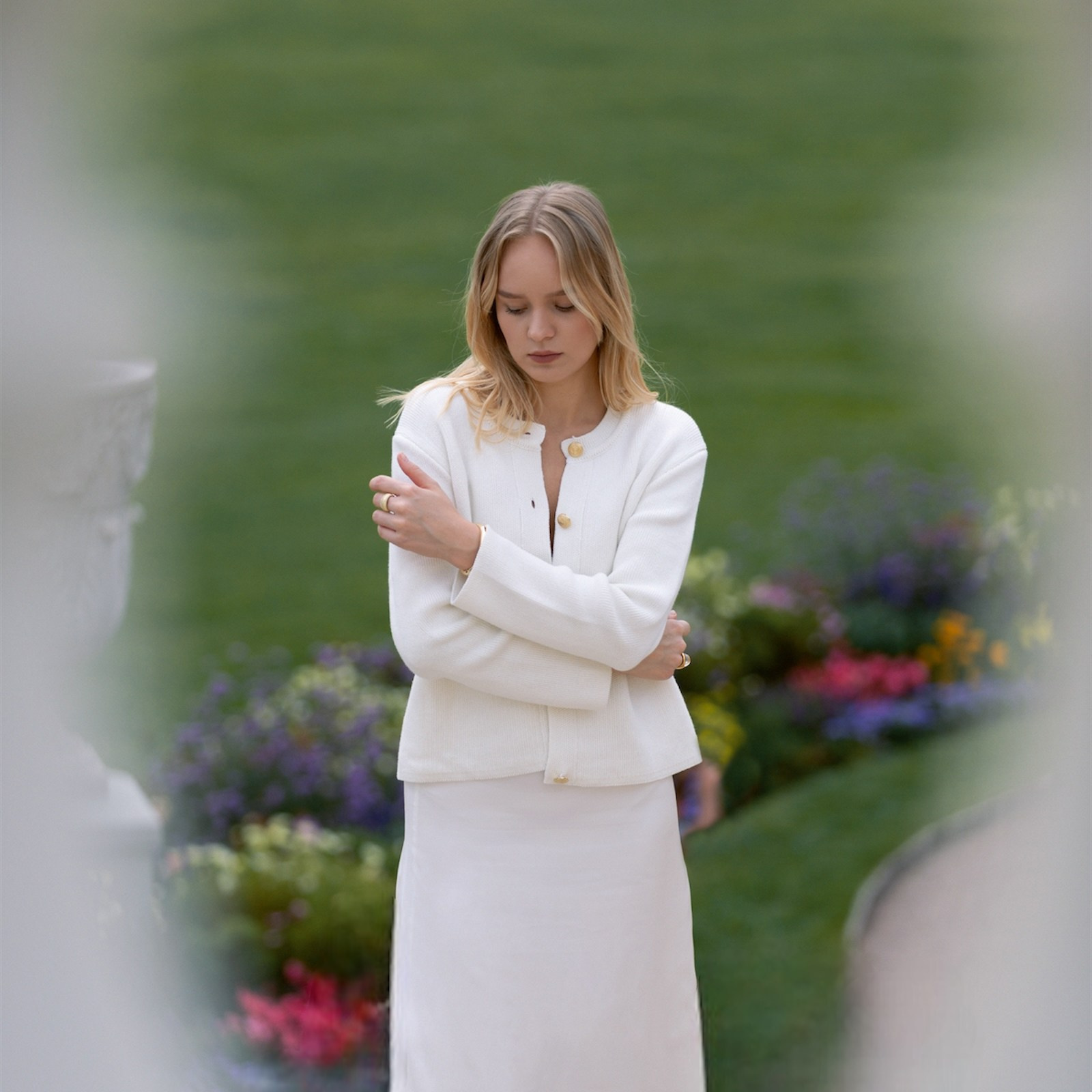 Девушка в белом платье стоит на фоне природы с закрытыми глазами. Фотосессия как способ внутреннего освобождения.