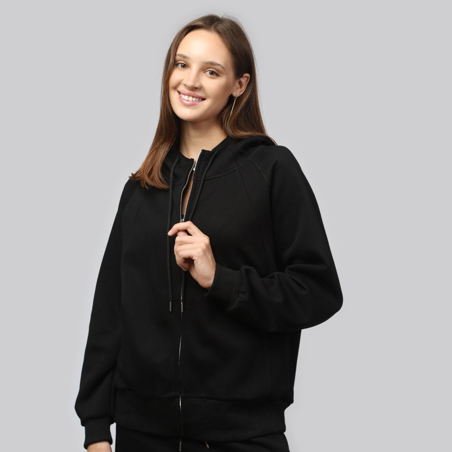 Модель в спортивном костюме на сером фоне — съемка одежды для интернет-магазина.