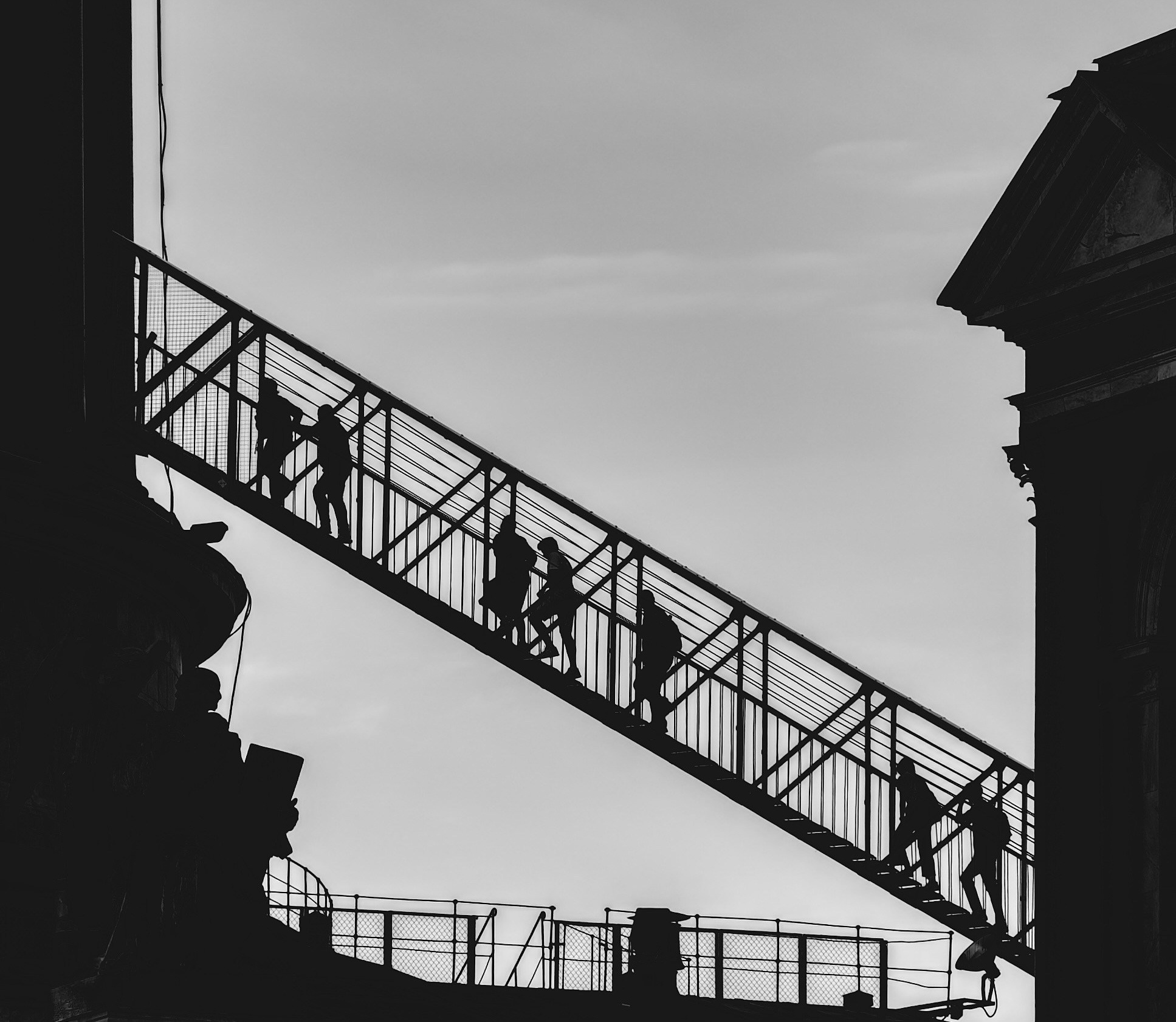 силуэты людей, поднимающихся по лестнице Исаакиевского Собора в Петербурге