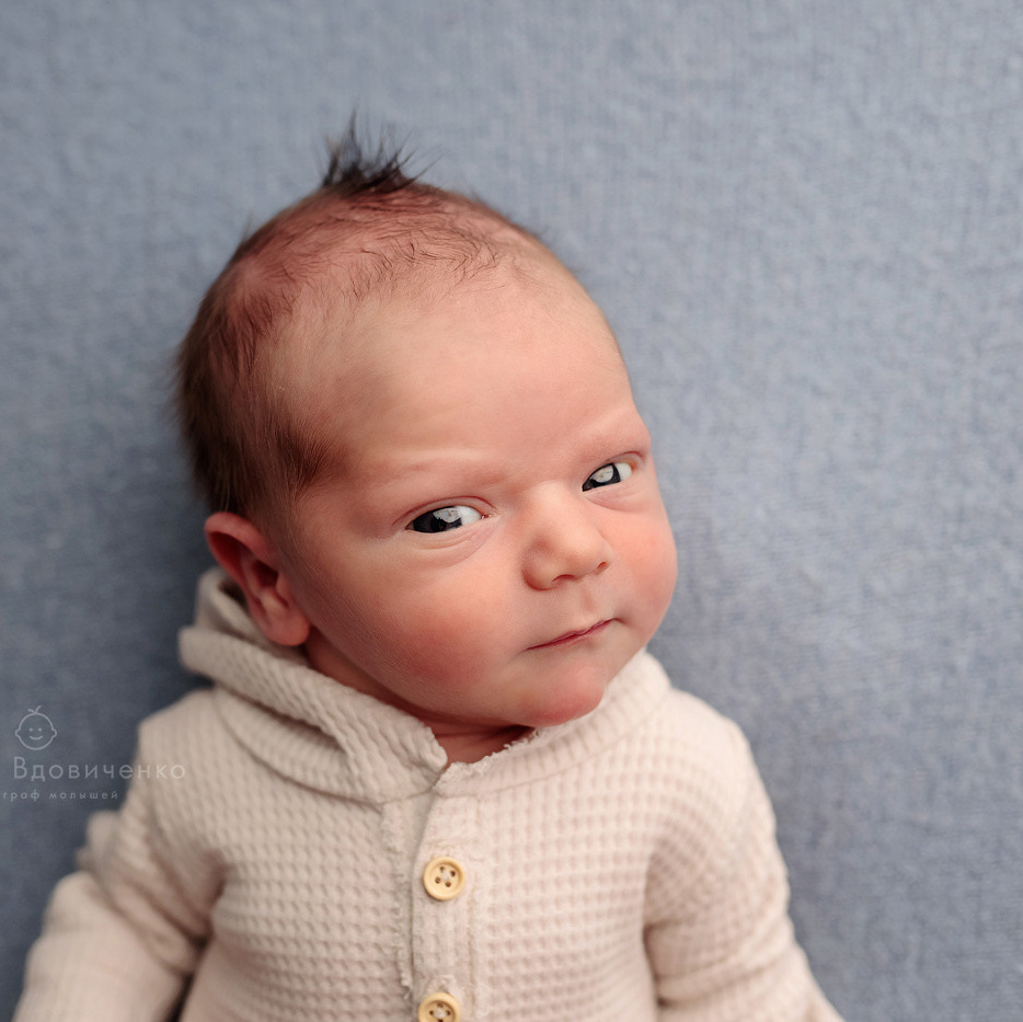 новороженный малыш смотрит