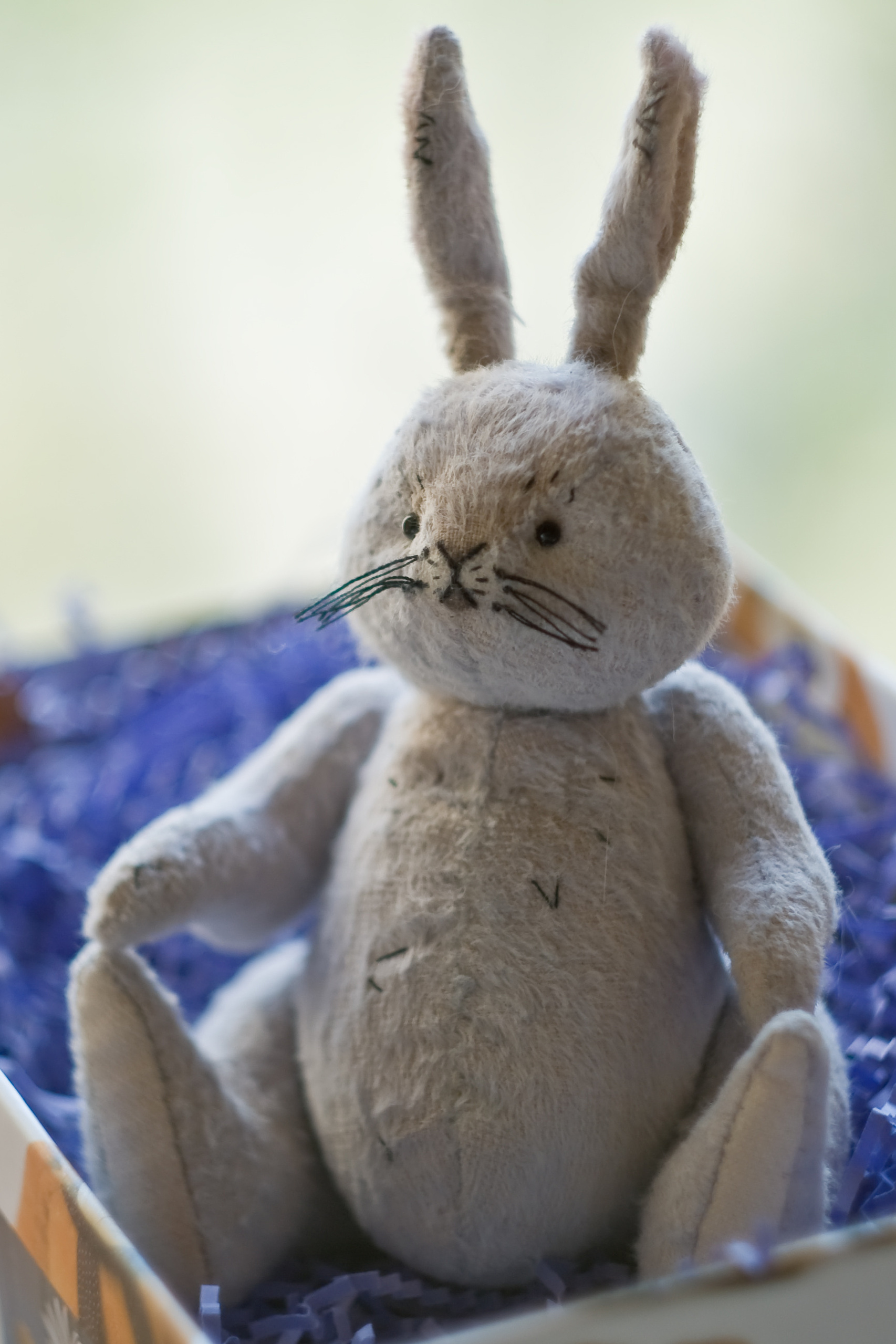 игрушечный кролик ручной работы сидит в открытой коробке