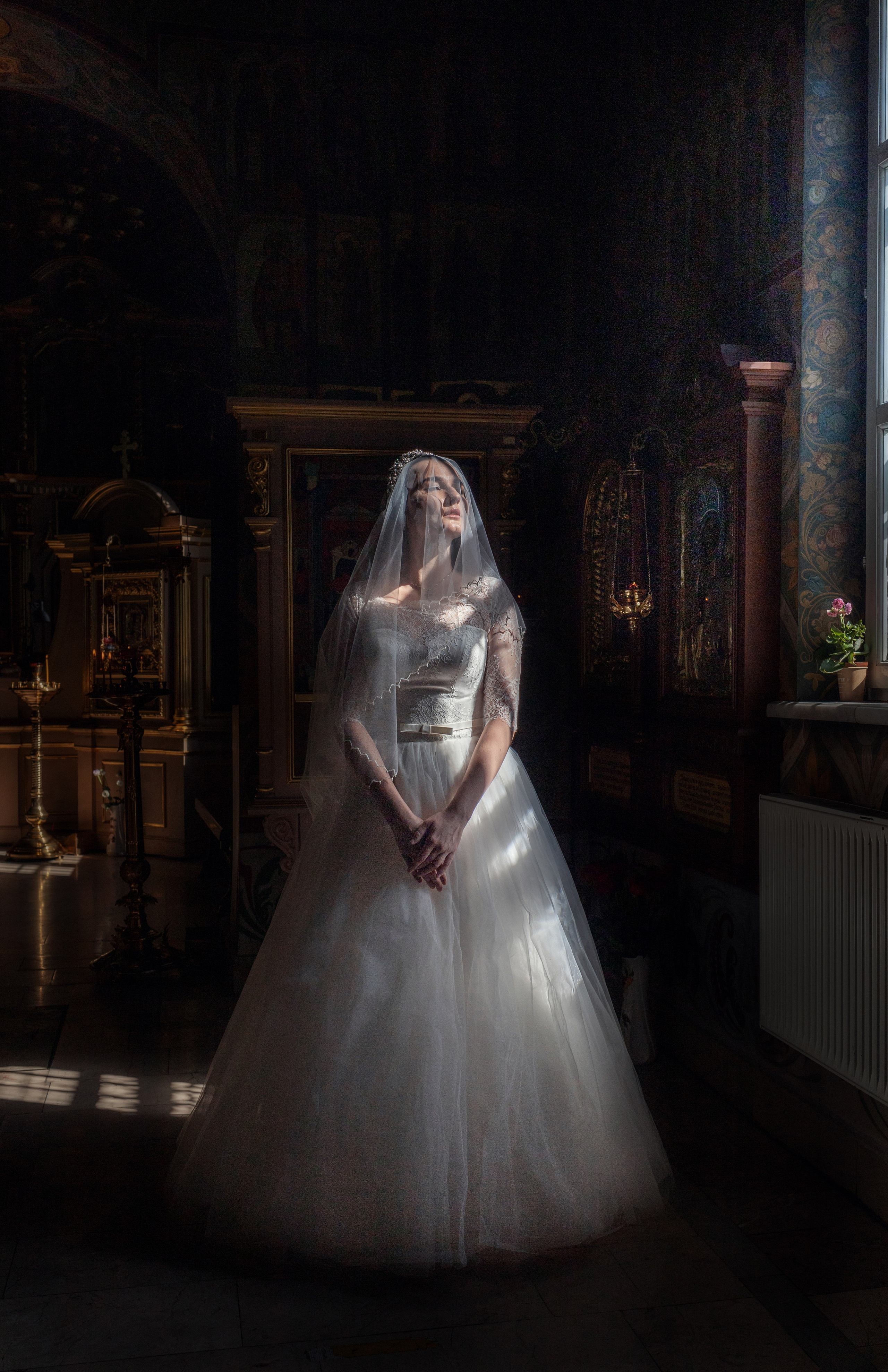 Невеста в храме перед Таинством Венчания. Мечтательно стоит у окна.