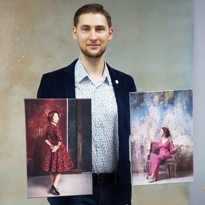 Андрей Рэй держит фотохолсты в руках