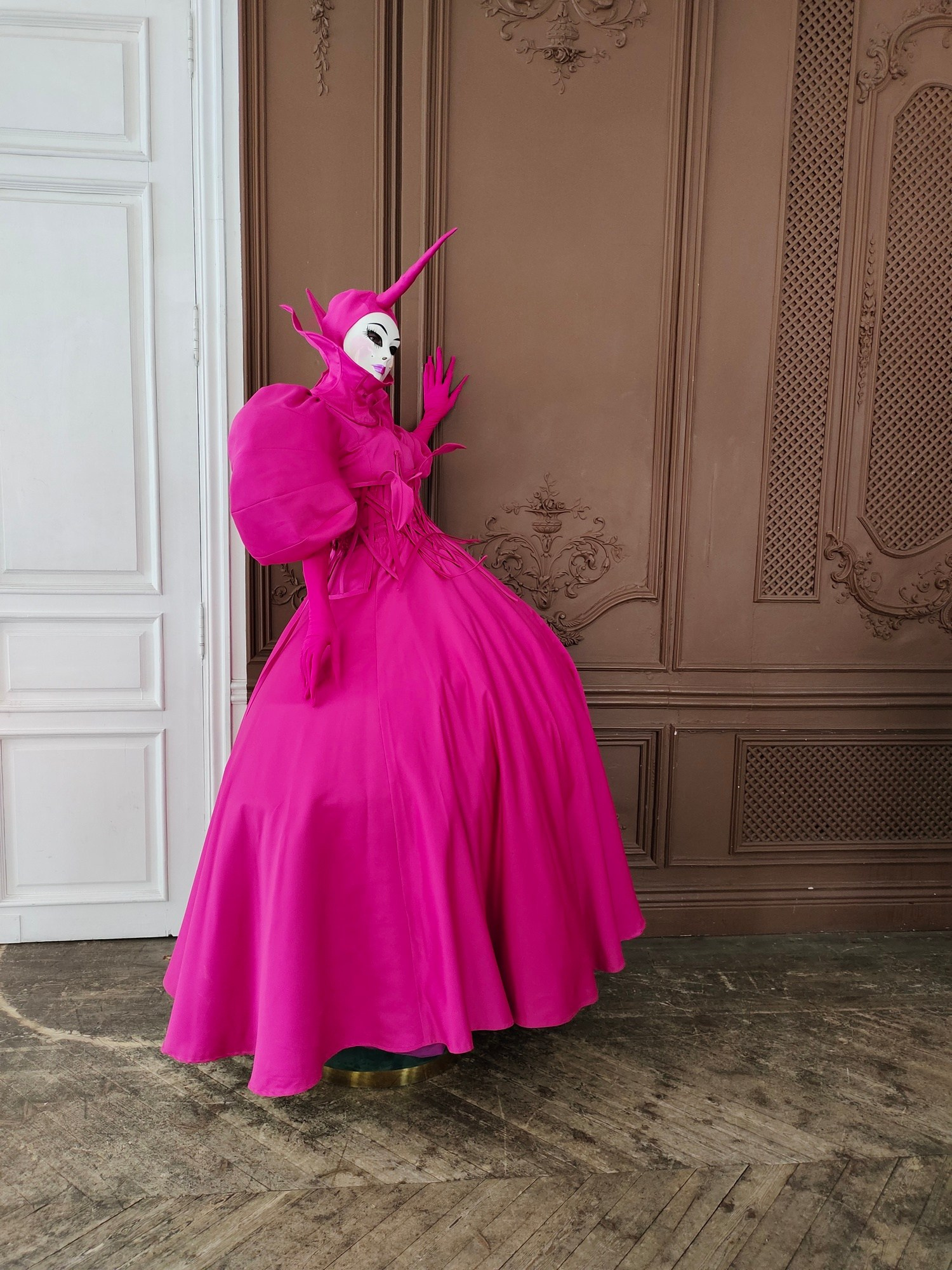 Артист в костюме цвета дикого цветка Фуксия встречает гостей в старинном особняке в Москве.