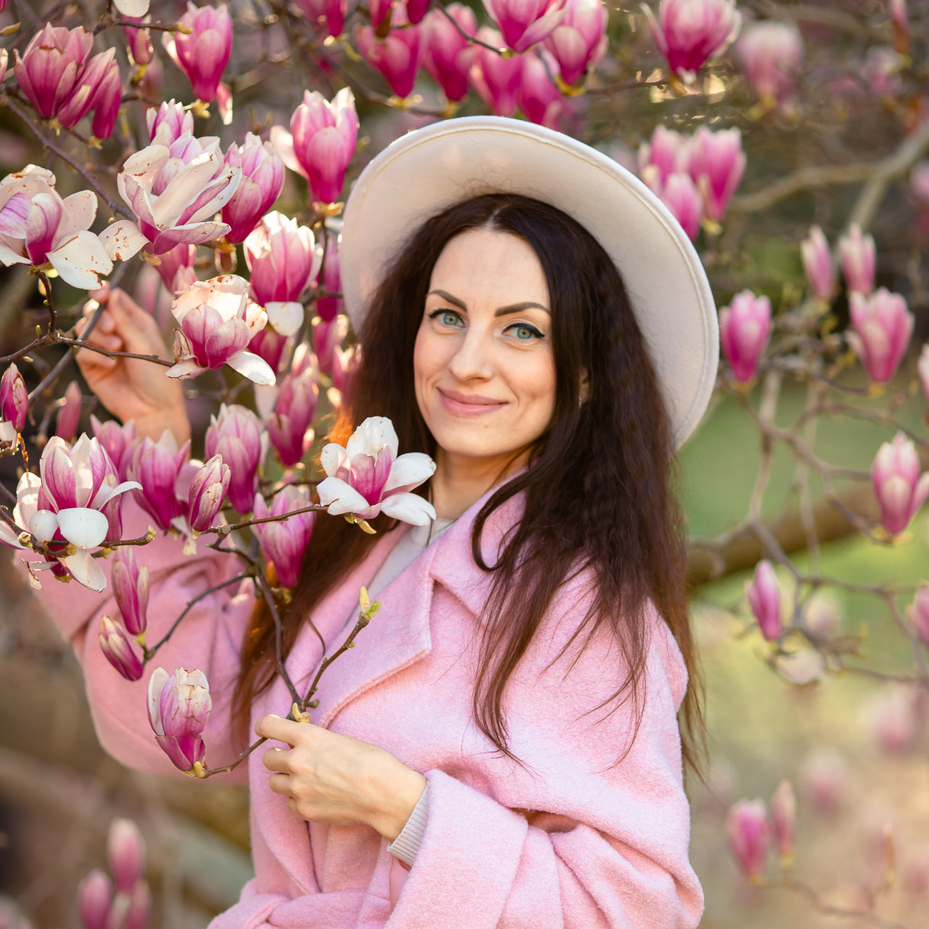 Красивая девушка держит цветок Магнолии в парке 