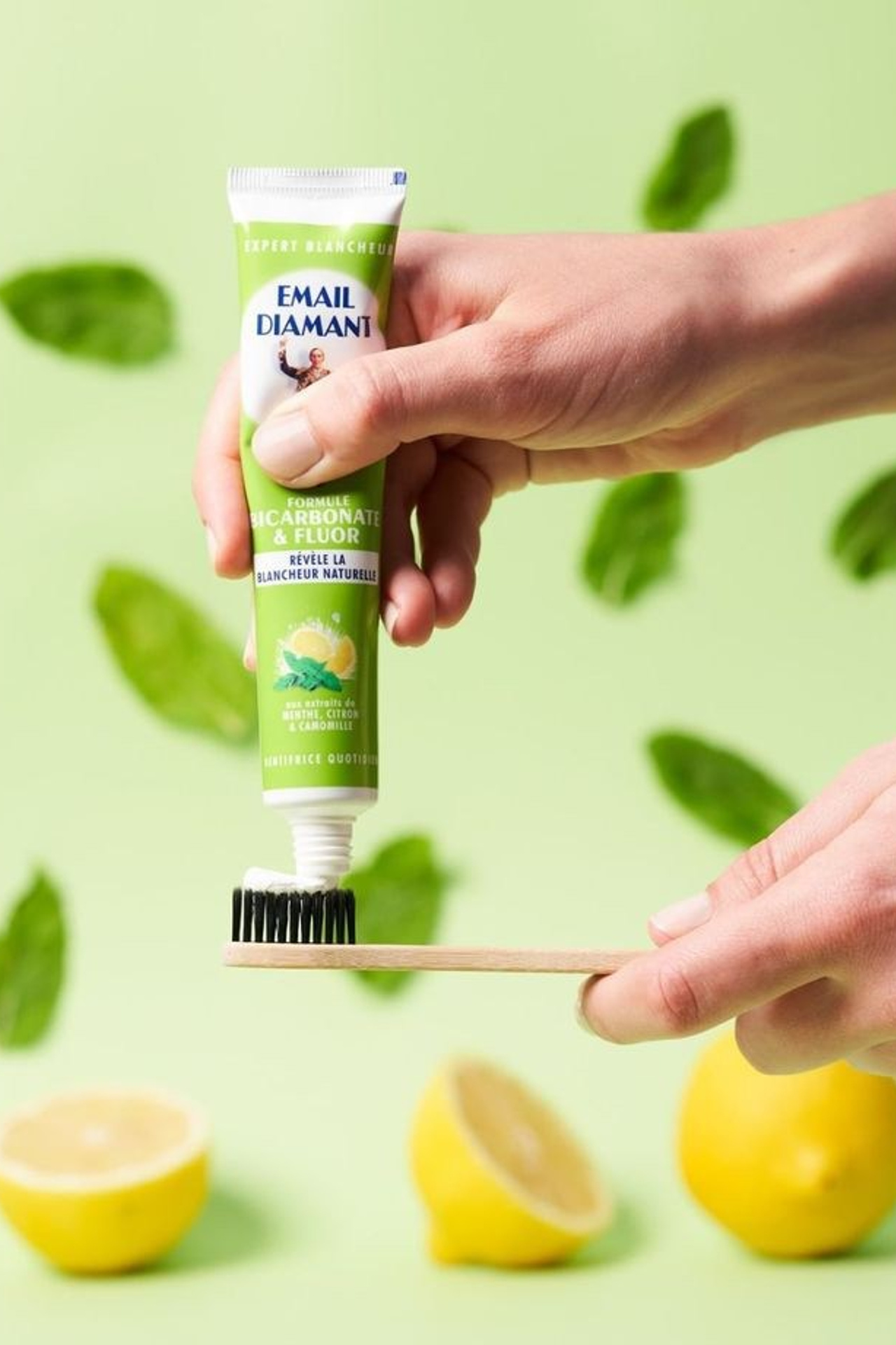 Предметная съемка зубной пасты в окружении мятных листьев.