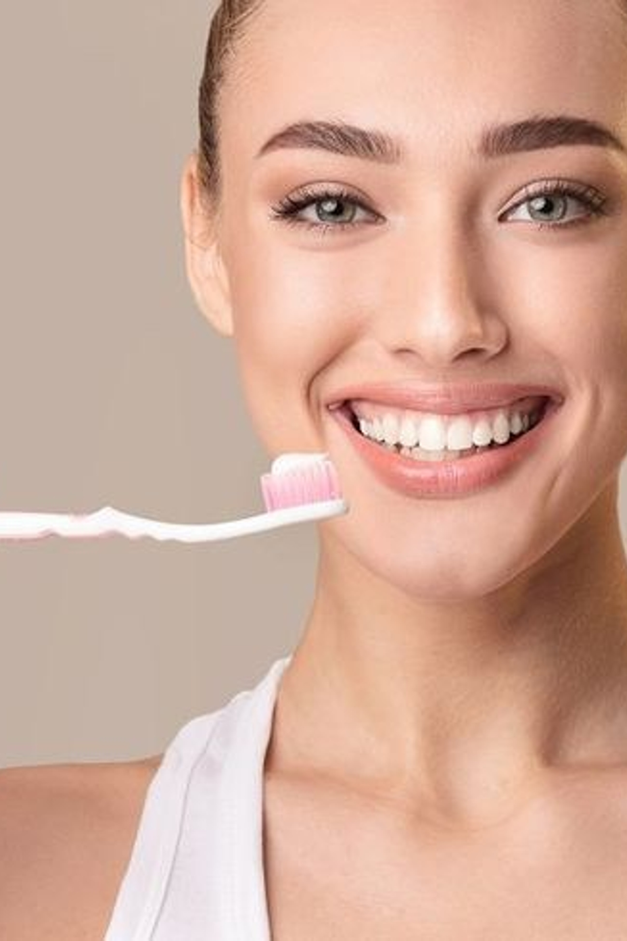 Предметная съемка зубной пасты с моделью, улыбающейся на фоне свежей композиции.