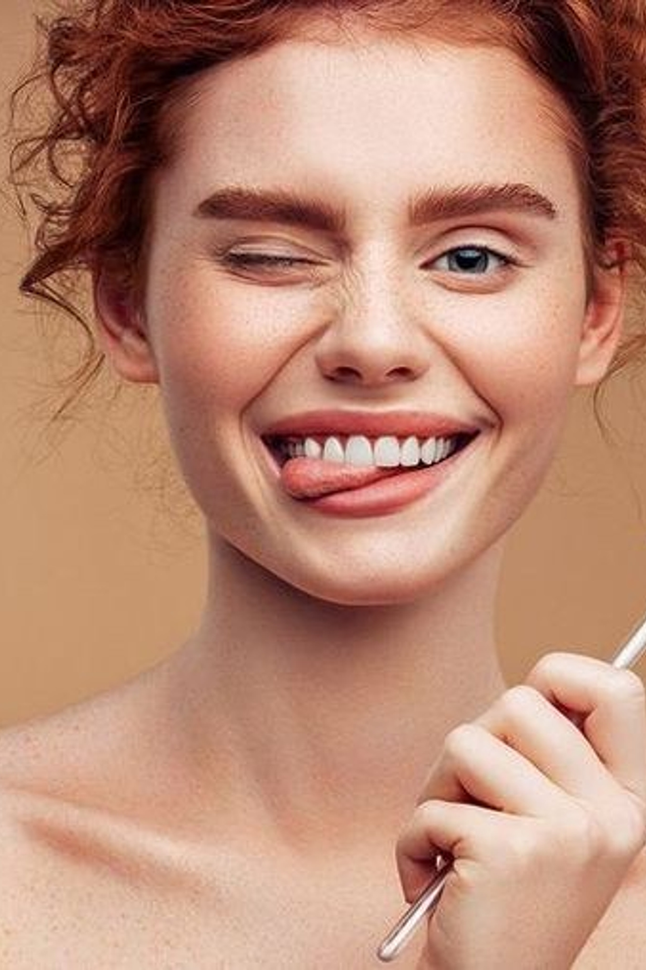 Предметная съемка зубной пасты с моделью, держащей щетку рядом с лицом.