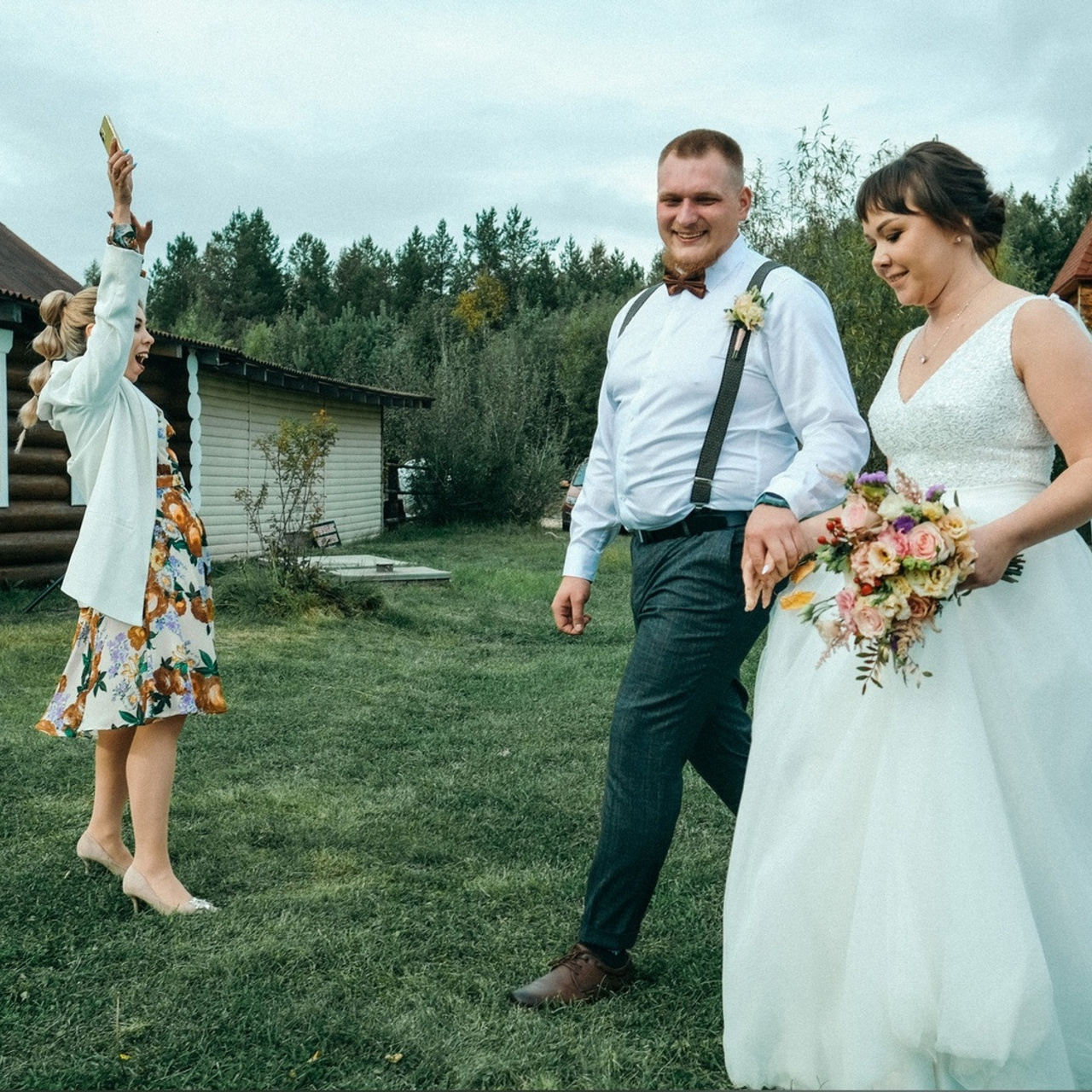 Жених и невеста молодожены Архангельска идут по зеленой траве