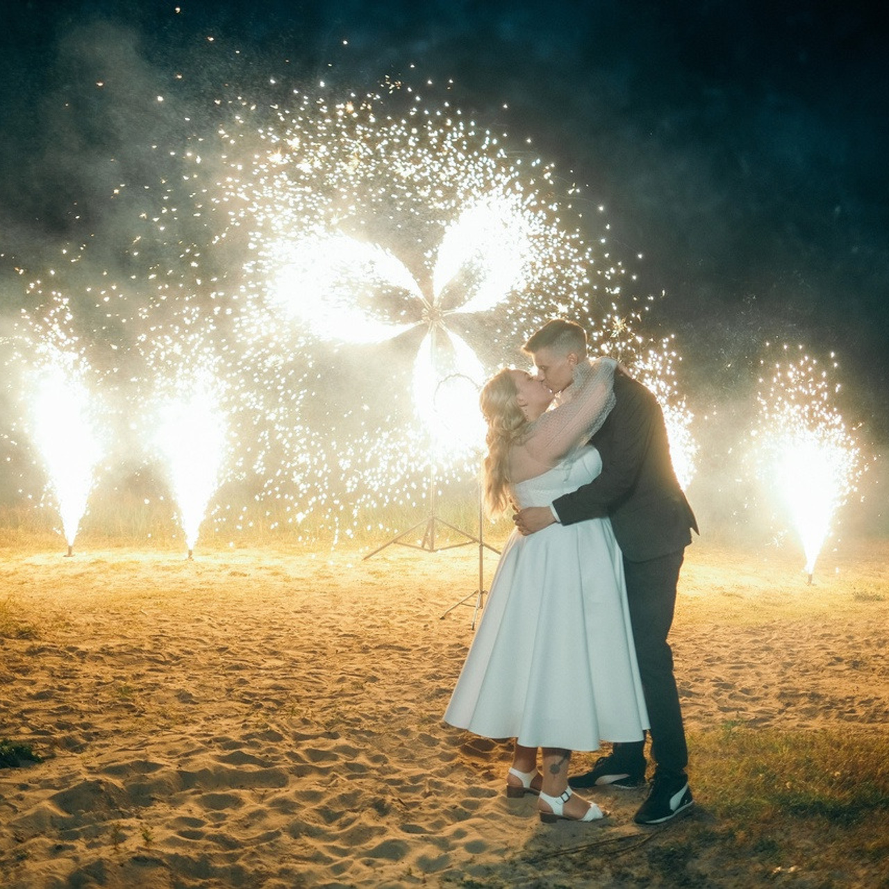 Свадебный поцелуй жениха и невесты в бенгальских огнях и пиротехническом шоу Идеи для финала свадебного банкета. 