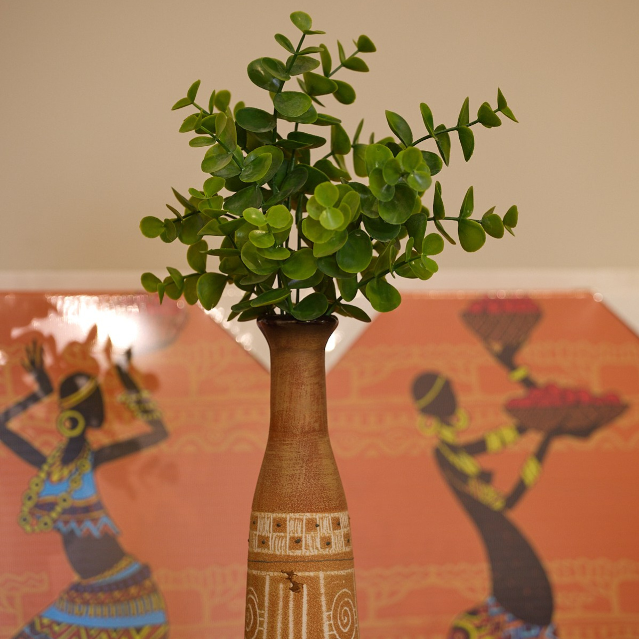 Декоративная вазочка с искусственными цветами, фото в подходящем по цвету интерьере.