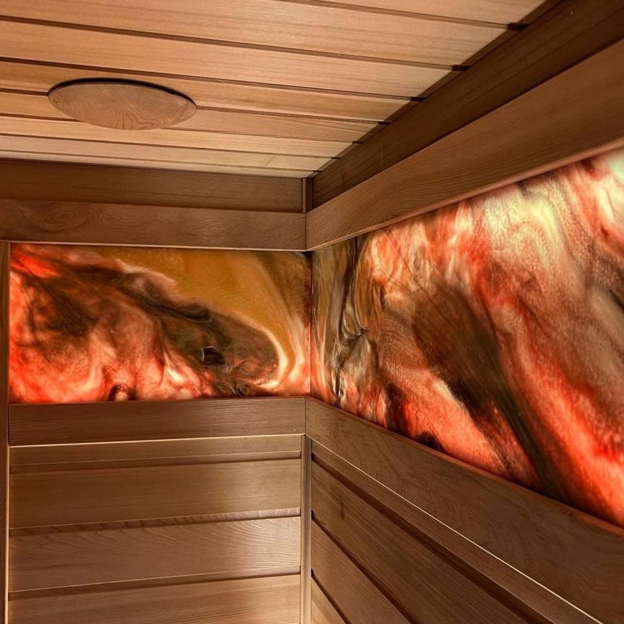 Баня в Сестрорецке, выполненная из кедра и абаша с ониксом, играющим цветом, создаёт тёплую и уютную атмосферу парения