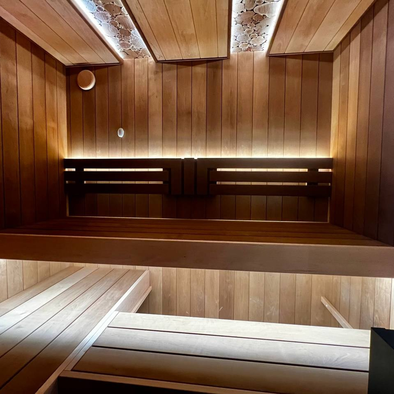 Сауна в Рощино на базе электрокаменки с парогенератором Harvia Virta выполнена из термоольхи с интеграцией световых линий из можжевельника