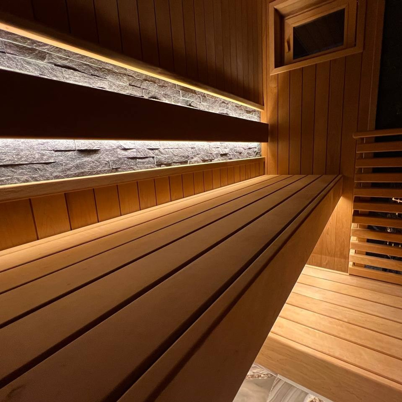 Семейная сауна в&nbsp;Охте: термоольха, природный камень и&nbsp;аккуратное реечное ограждение печи, защищающее любопытные детские ручки