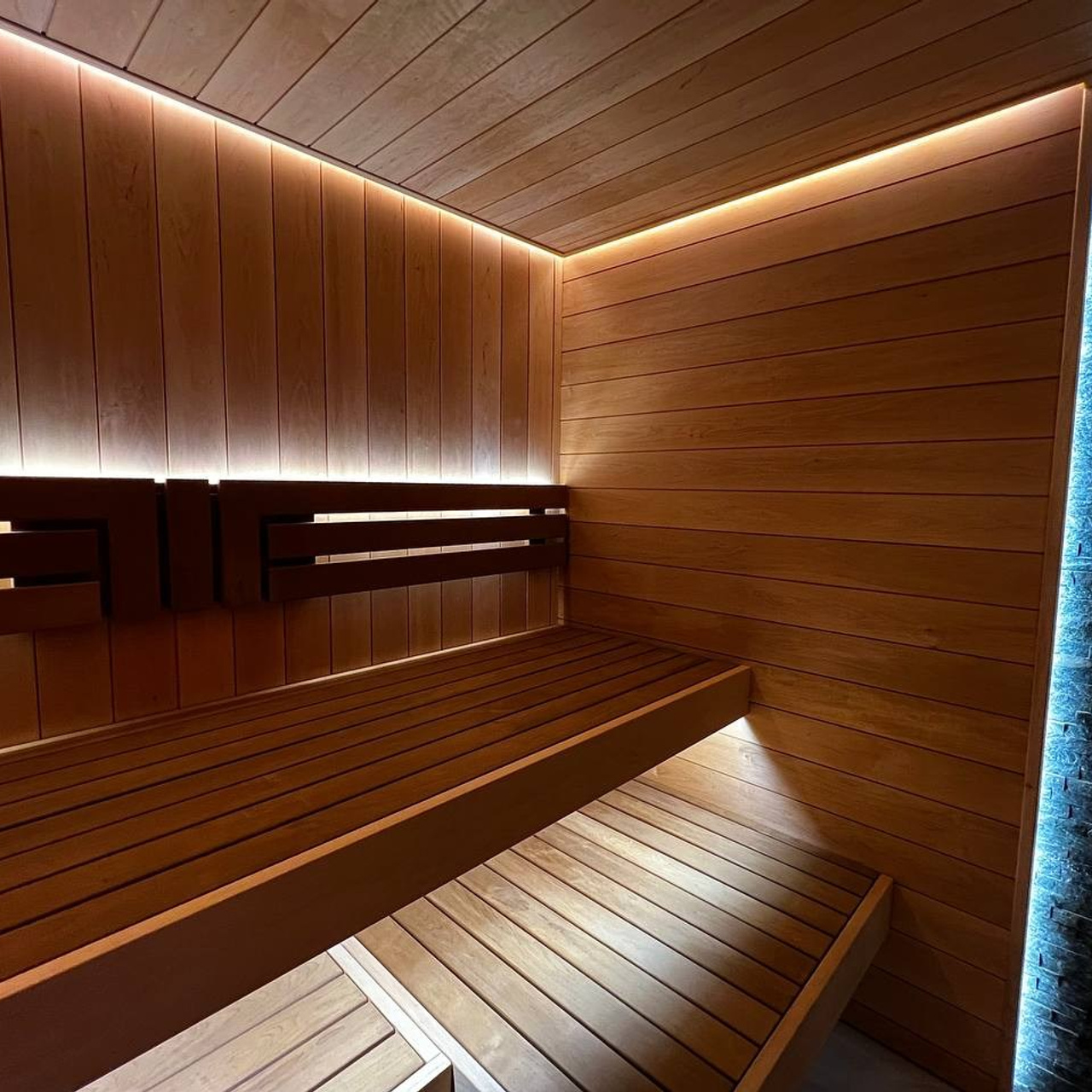 Уютная сауна в КП Новый Мир. В центре внимания- Harvia Cilindro, а закарнизное освещение плавно перетекает в подсветку противопожарного угла