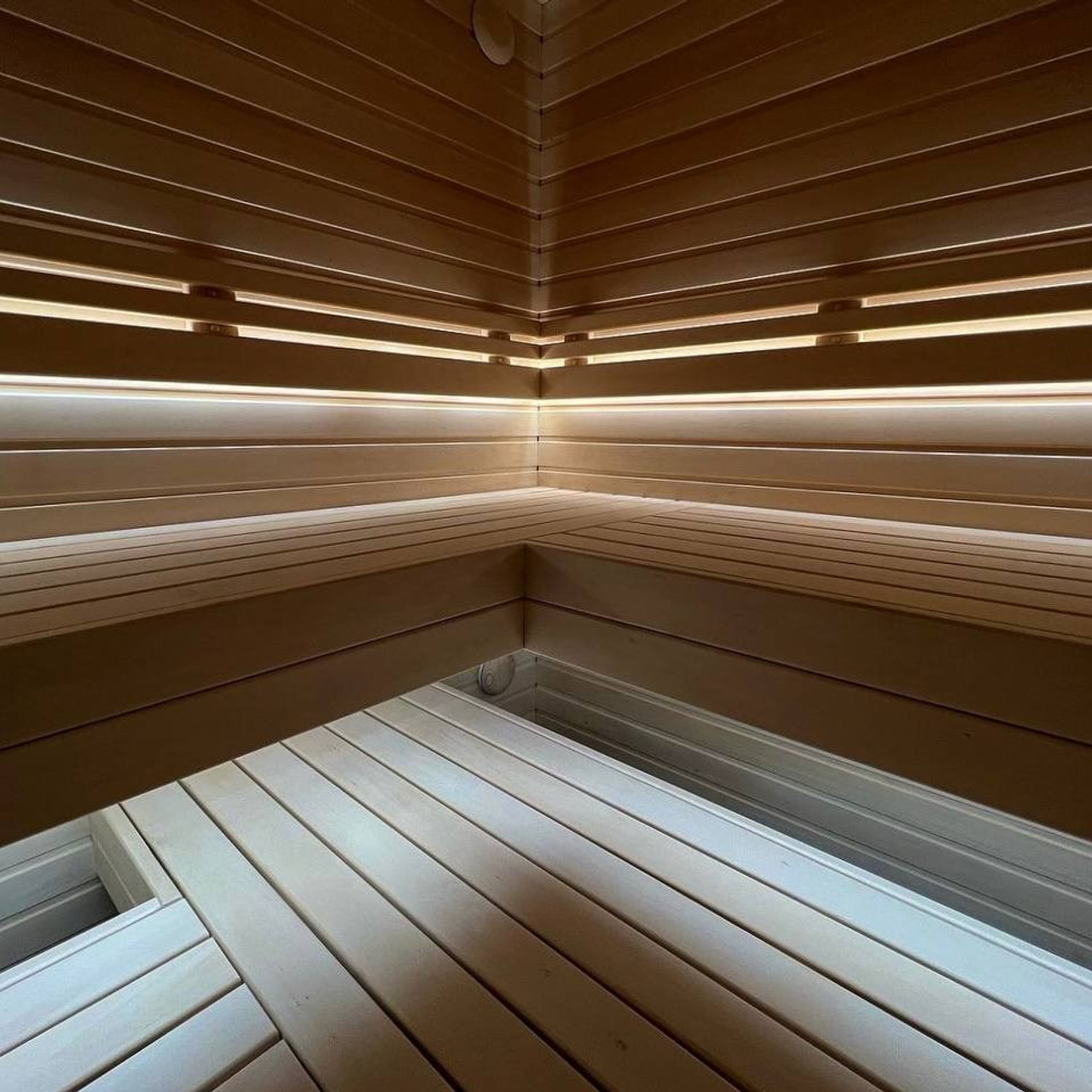 Сауна на морских террасах из осины и африканского абаши. Вертикальная укладка натурального камня-редко, но эффектно