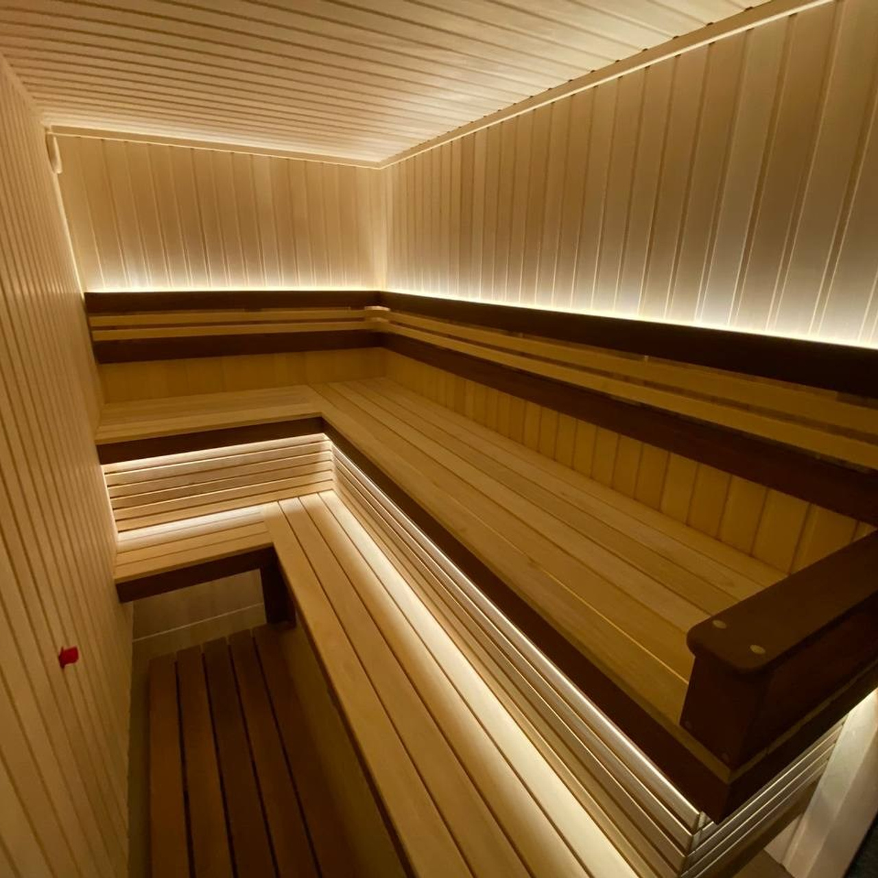Семейная сауна в Кузьмолово на базе Harvia Glow. В отделку из липы встроены просторные полки из комбинации абаши+ термоабаши