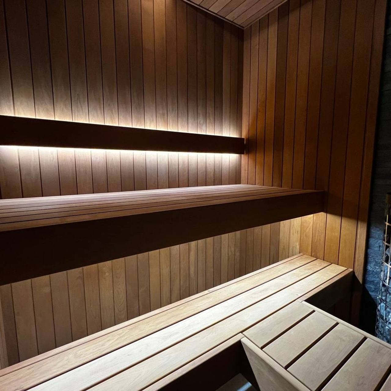 Компактная сауна в&nbsp;Охта Парке с&nbsp;электрокаменкой Harvia Cilindro, отделкой из&nbsp;термоольхи и&nbsp;сияющим можжевеловым панно