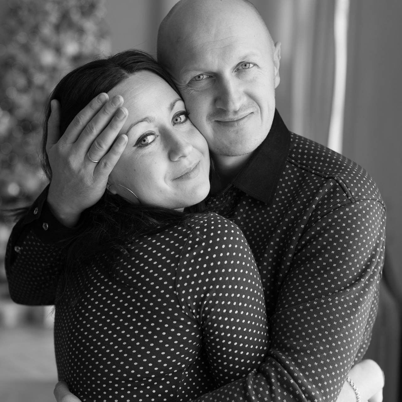 Семейная новогодняя фотосъемка в студии, нежные объятия супругов 