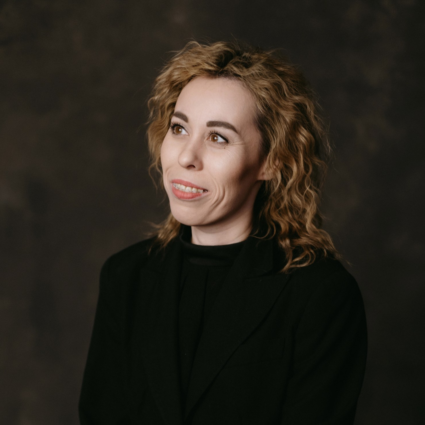 Ведущая и организатор Дарья Симонова с бенгальскими огнями в белом пиджаке улыбается 