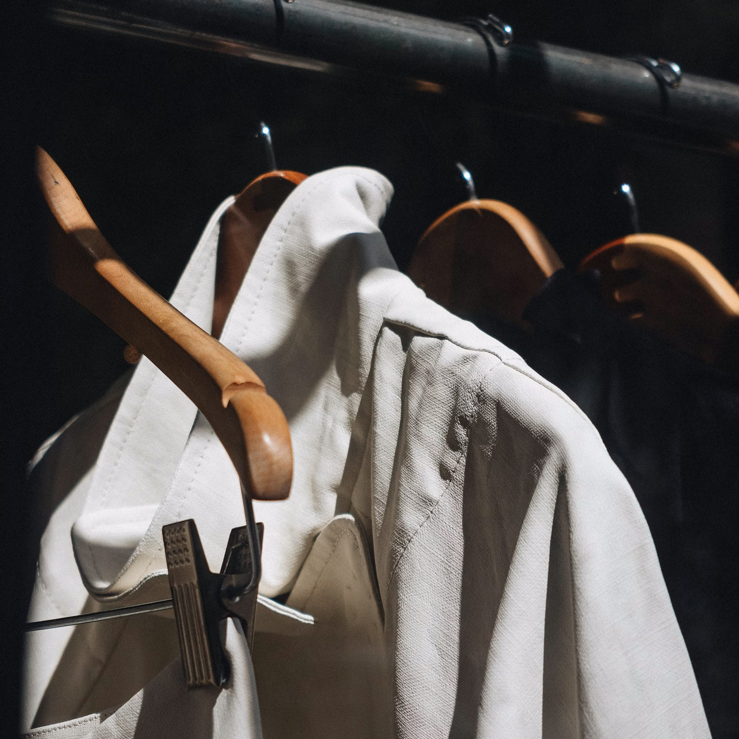 Светлое пальто и шляпа на вешалке – пример подбора образа стилистом