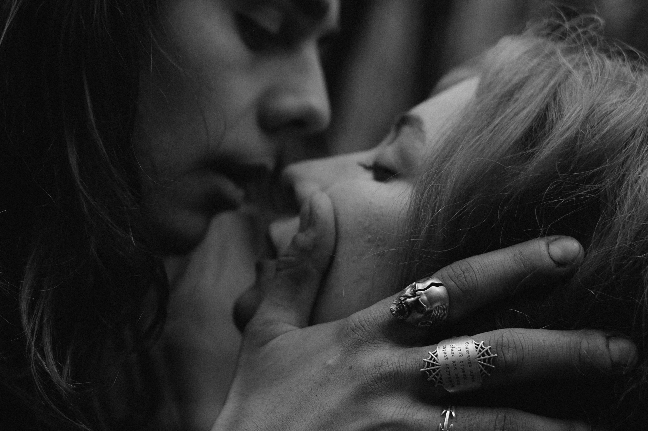 Крупным планом парень собирается поцеловать девушку, на его пальцах кольца