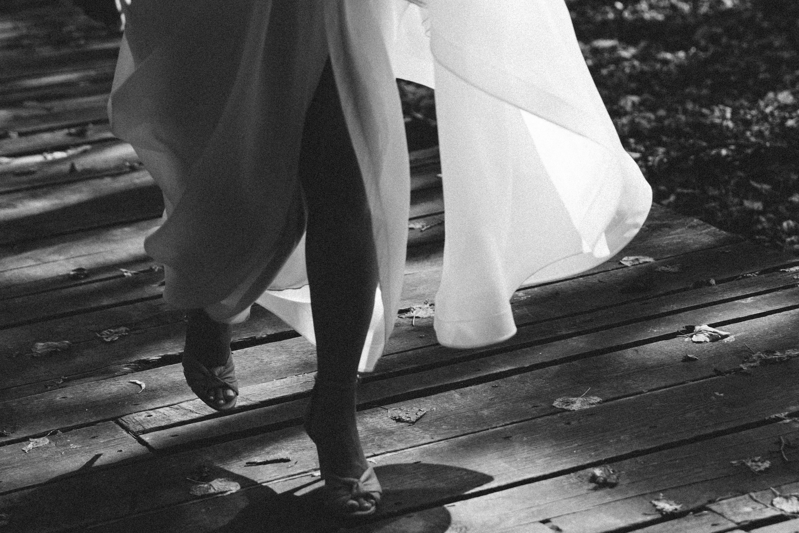 Невеста кружится со свадебным платьем на кровати. Снято через через лампочки, которые светятся на переднем плане. Свадебный фотограф Домодедово, Подольск, Москва.