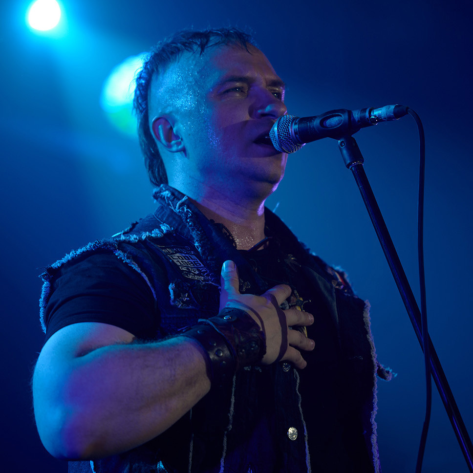 репортажная фотография рок концерта, музыкант на сцене поет