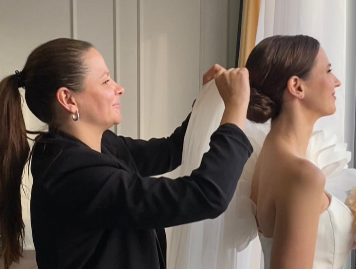 Визажист работает кистью для пудры у лица невесты