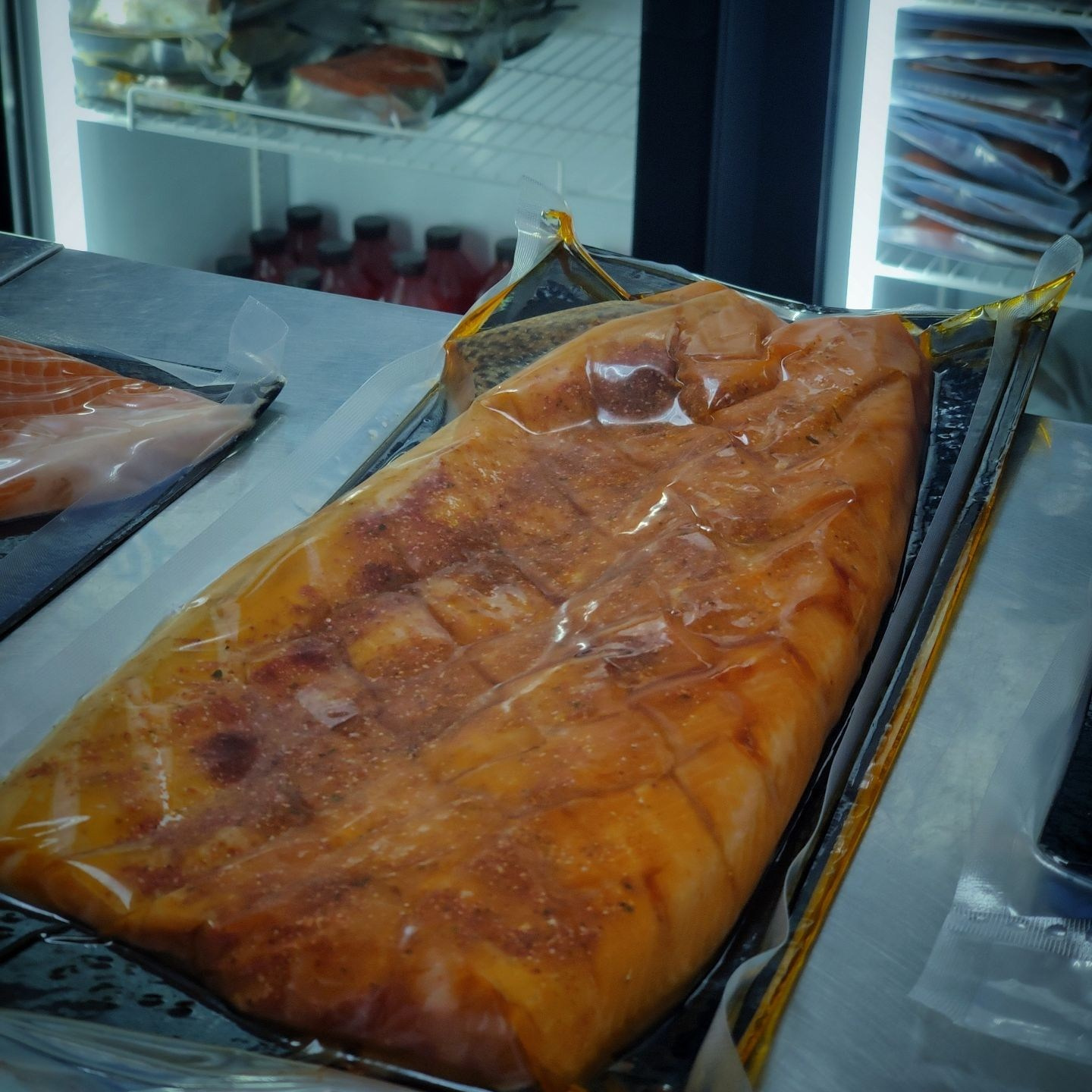 Форель холодного копчения лежит в упаковке на витрине в магазине