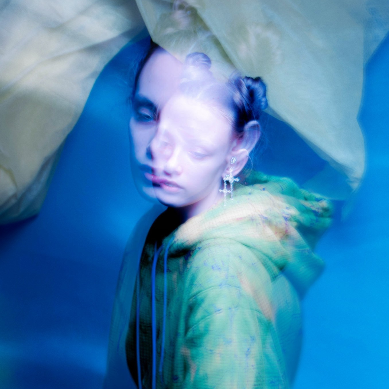 Фотография девушки в зеленом худи на синем фоне