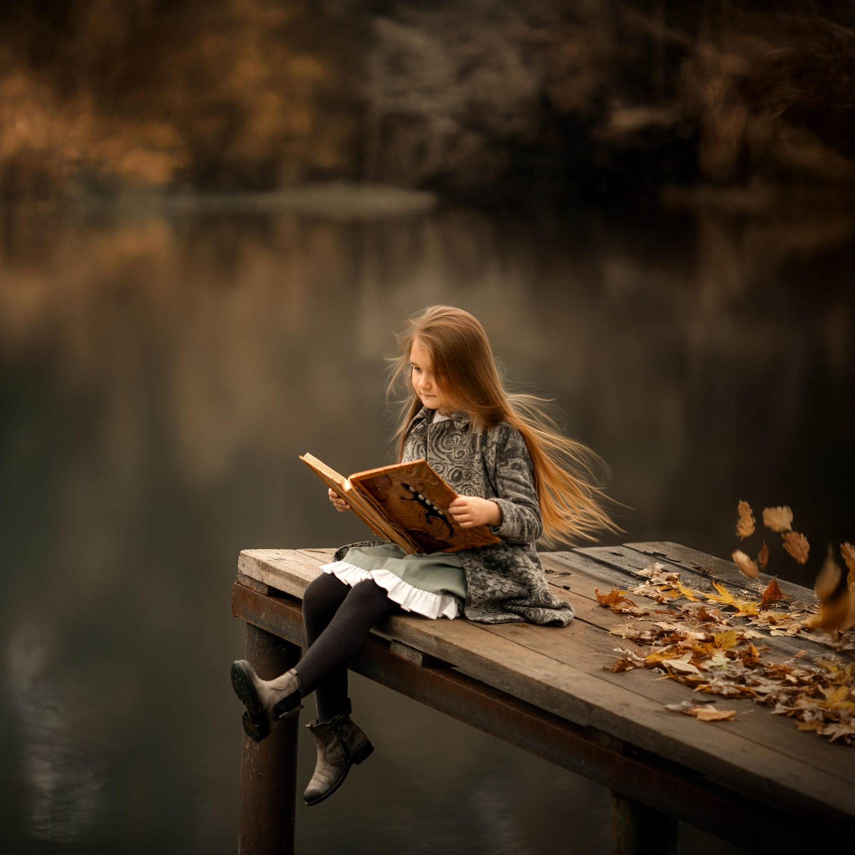 Открытый ноутбук с визуальной концепцией сайта, творческий процесс создания авторского сайта на деревянном столе в солнечном свете.