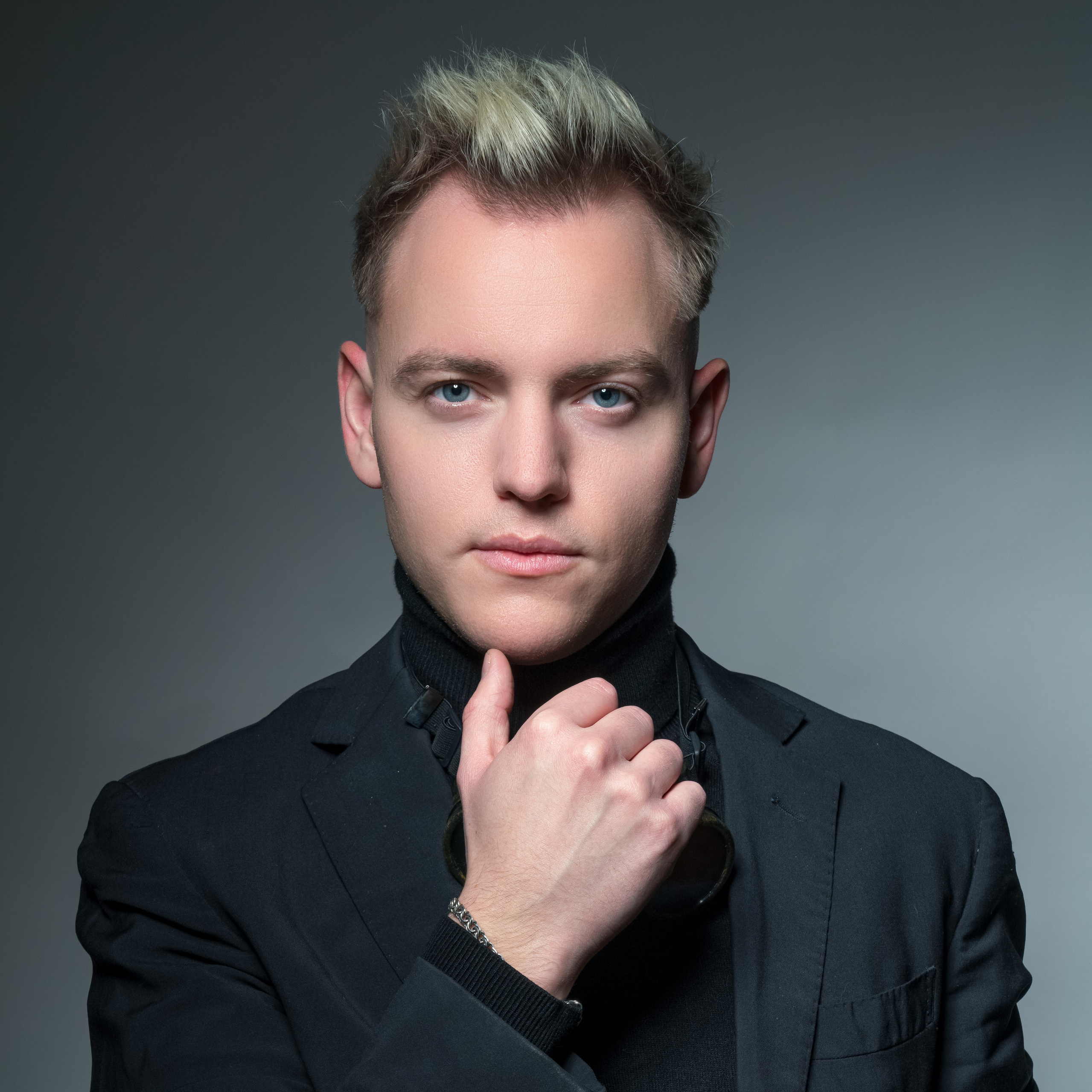 Портрет ученика 11 класса в чёрной одежде с белыми волосами. Работа студии Вышка в Москве.