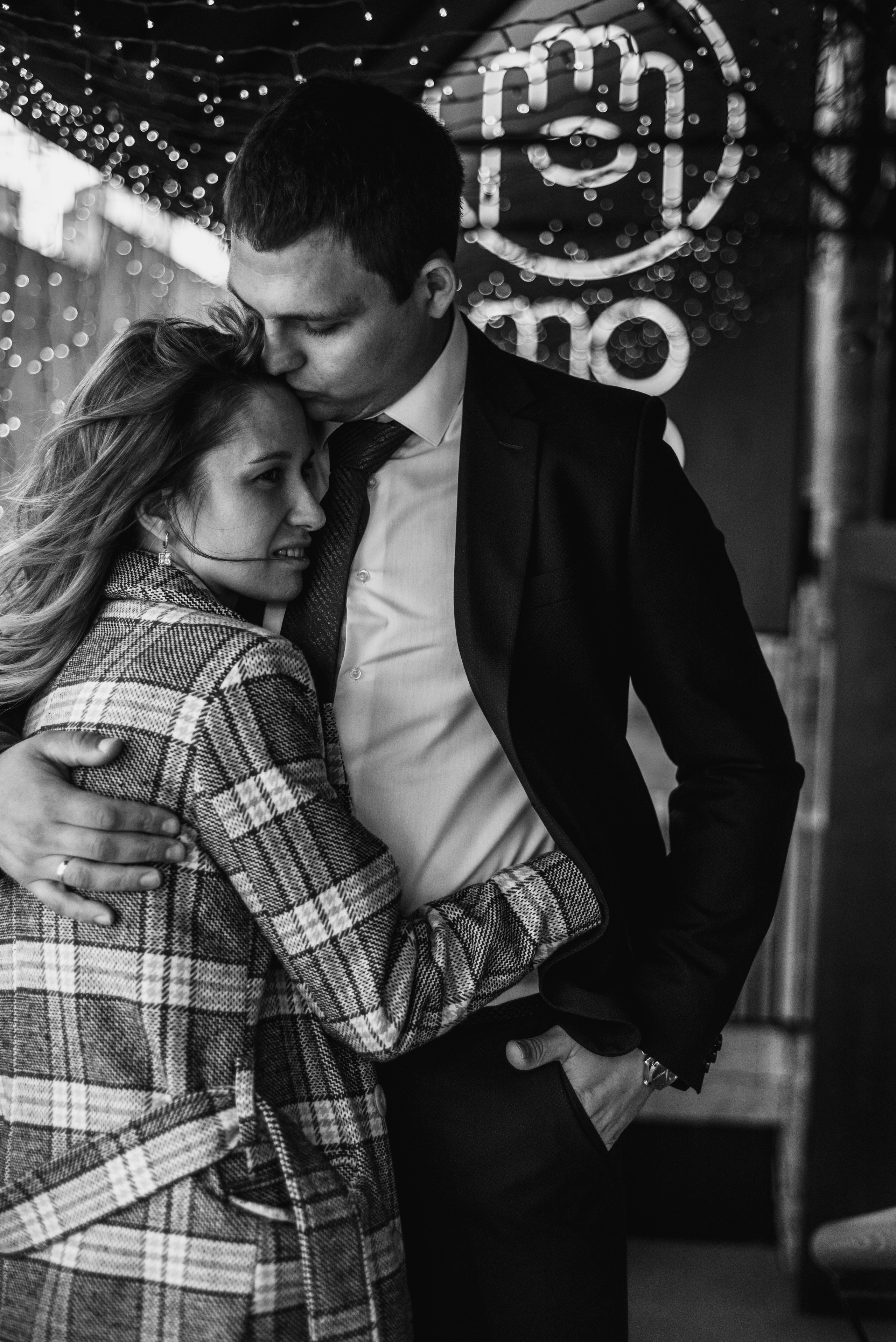 Влюбленная пара в обнимку на фоне кафе