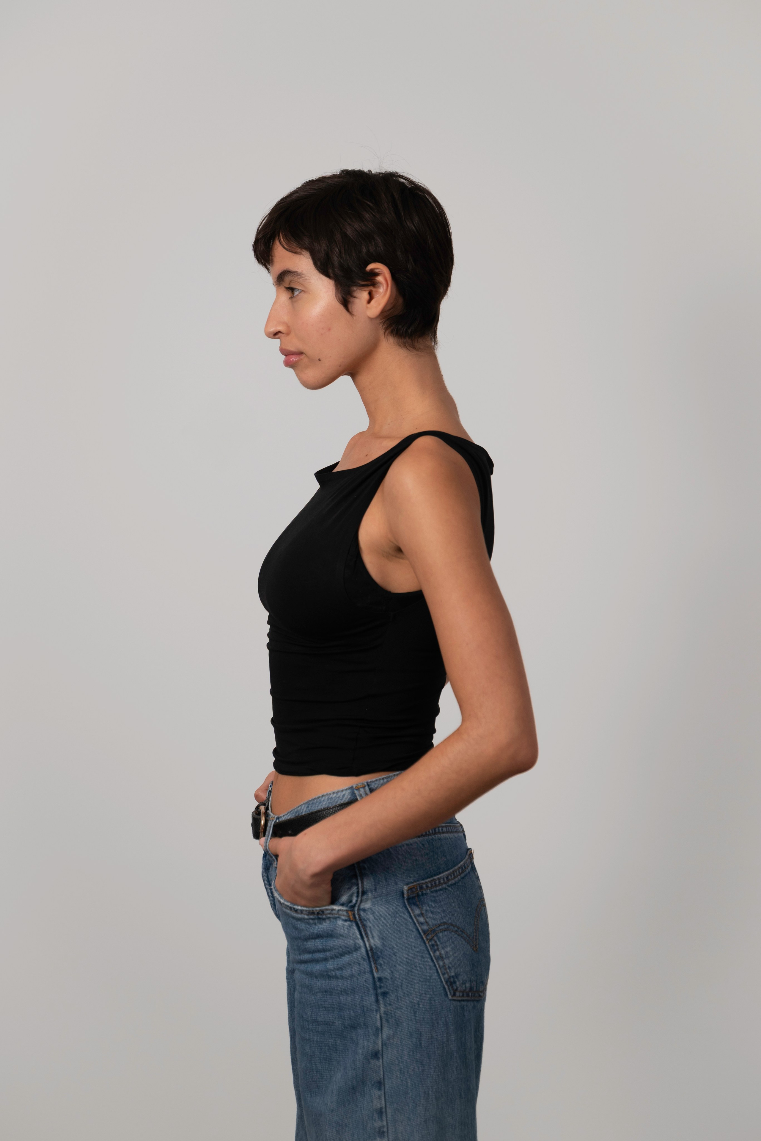 Side-profile model digital in a black top and jeans, photographed by Anasta Fo