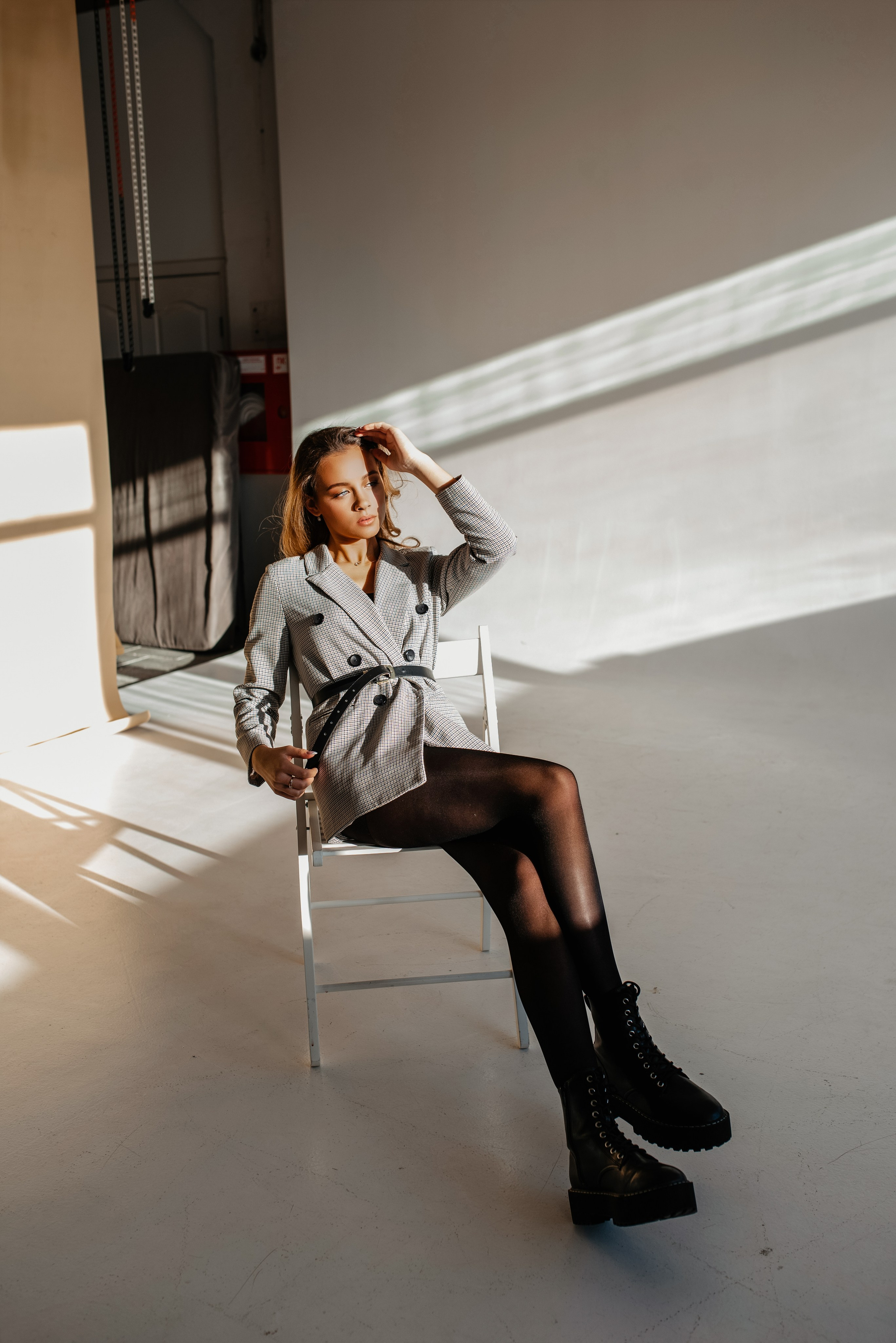 Девушка на фотосессии в фотостудии сидит на стуле в пиджаке pinterest