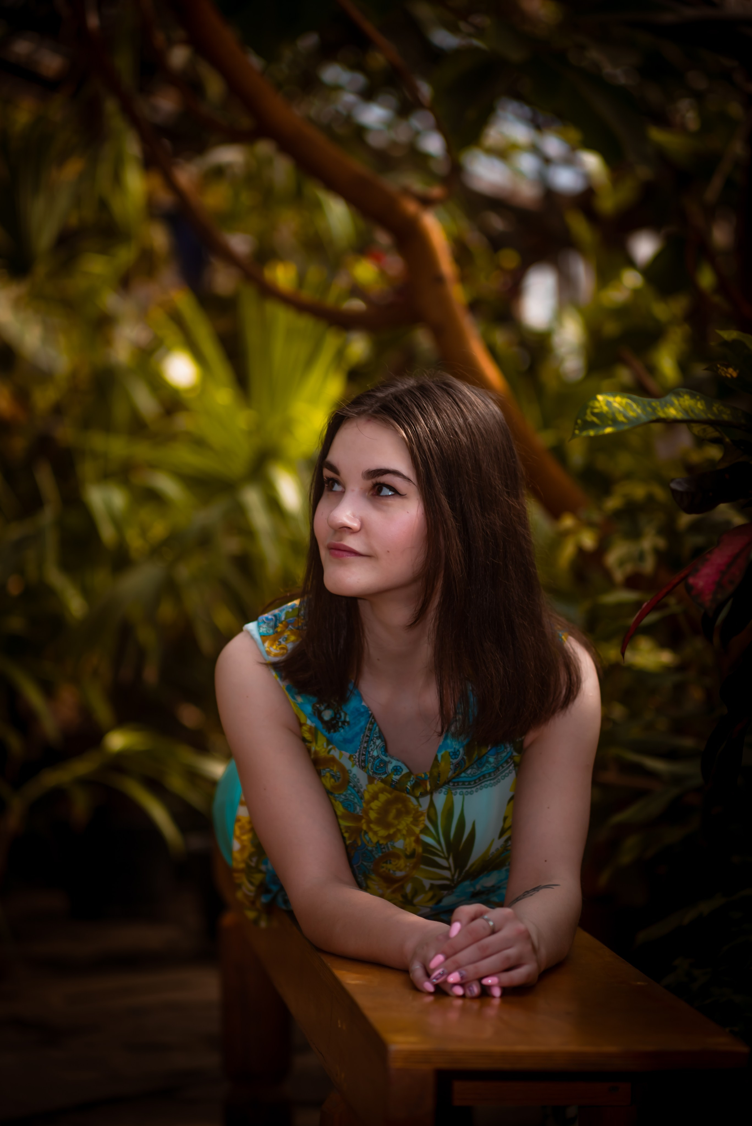 Девушка позирует на фоне зелени крупный портрет