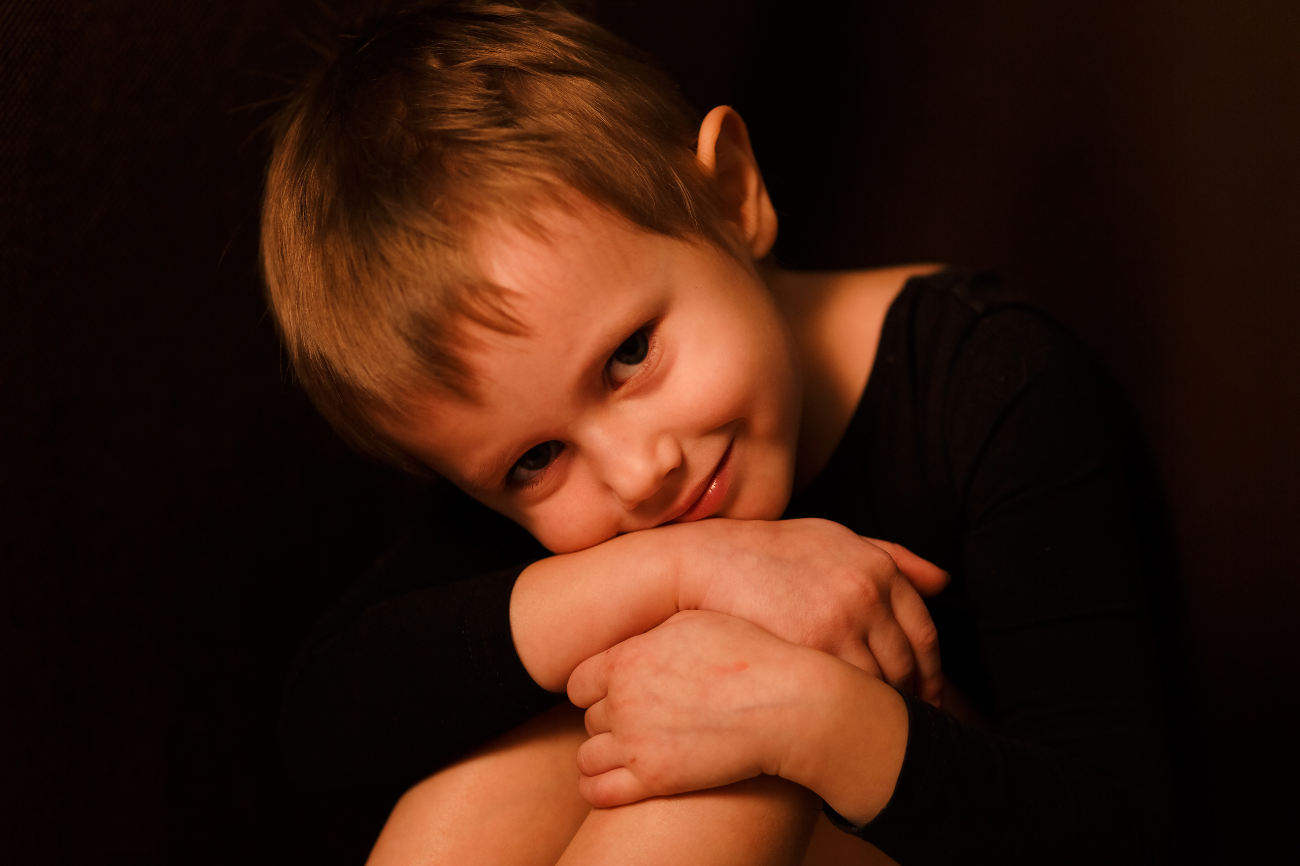 Портрет маленькой девочки в черном гимнастическом купальнике на черном фоне на детской фотосессии от фотографа Галины Шараповой