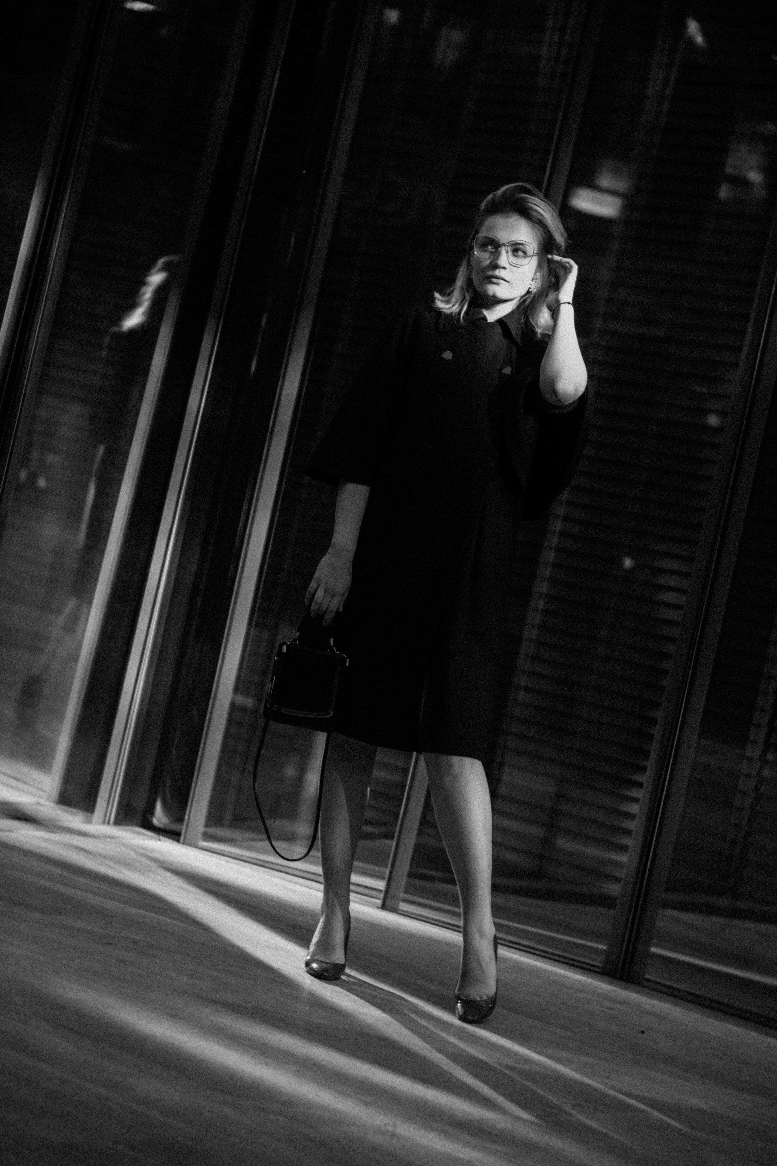 Девушка держит руками воротничок, ветер раздувает волосы