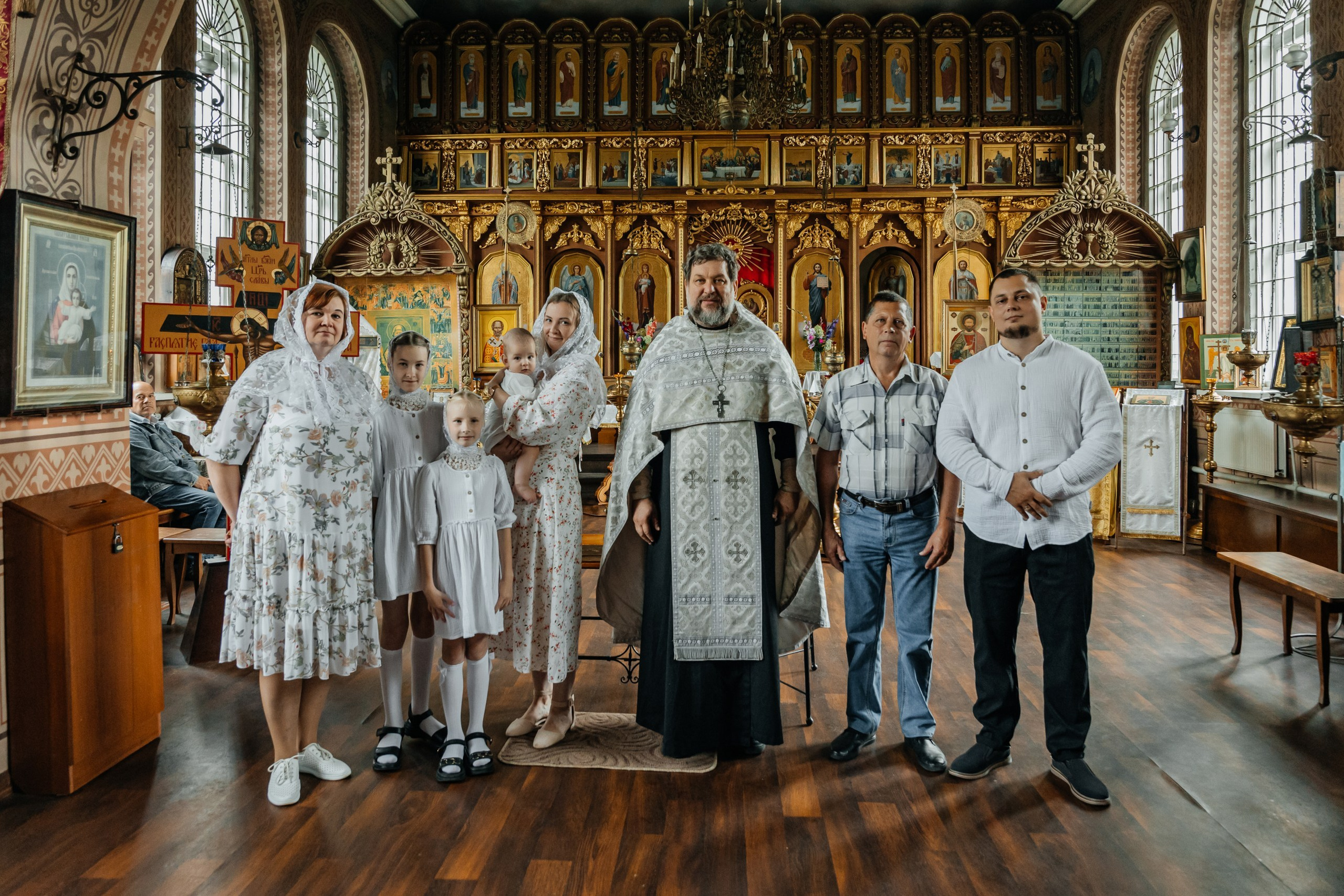 Ребёнок на руках у родителей в храме