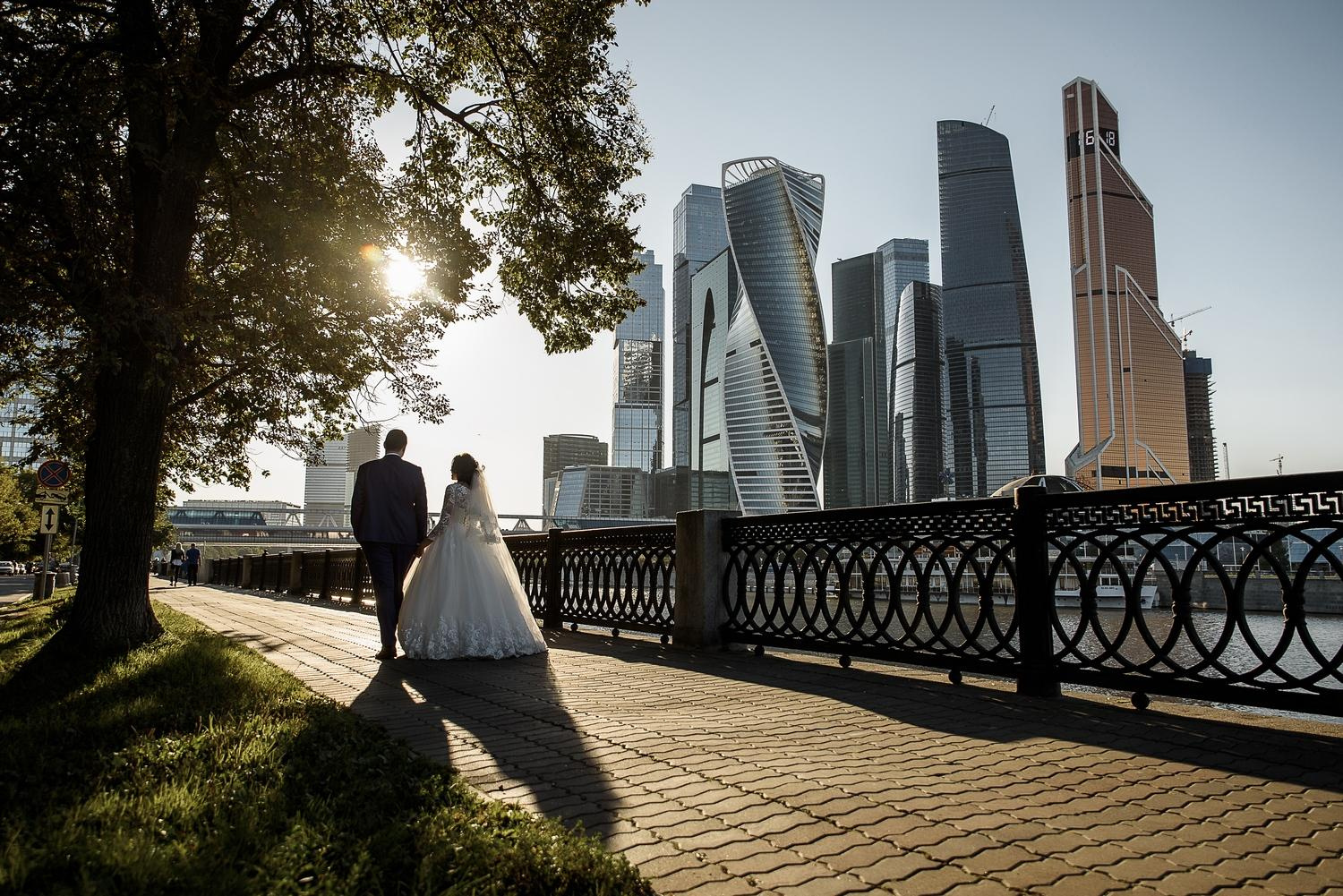 Молодожены идут по набережной на фоне Москва сити Свадебный фотограф в Москве Сергей Гаварос