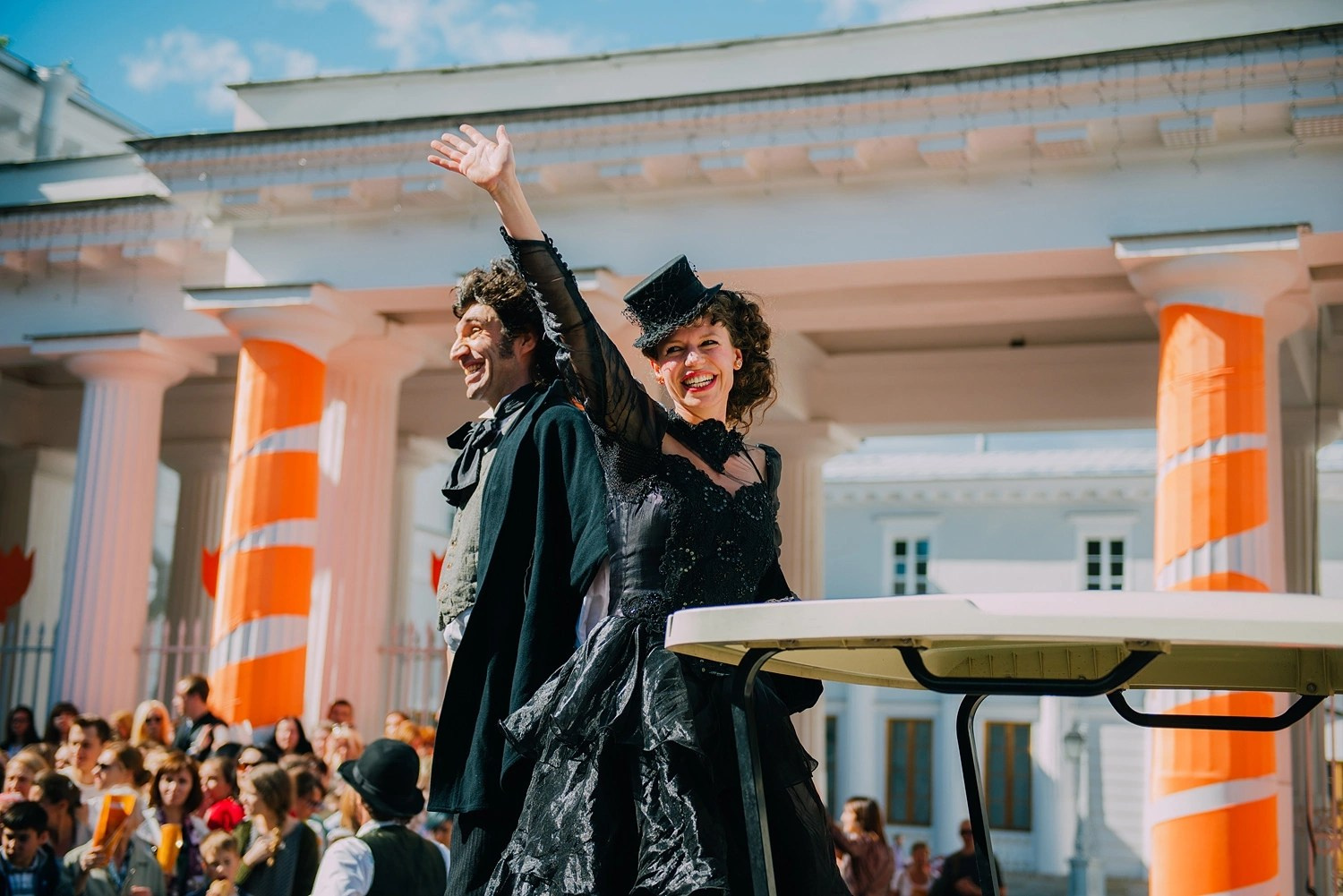 Репортажная съёмка мероприятия в Москве на улице девушка в центре кадра машет рукой.