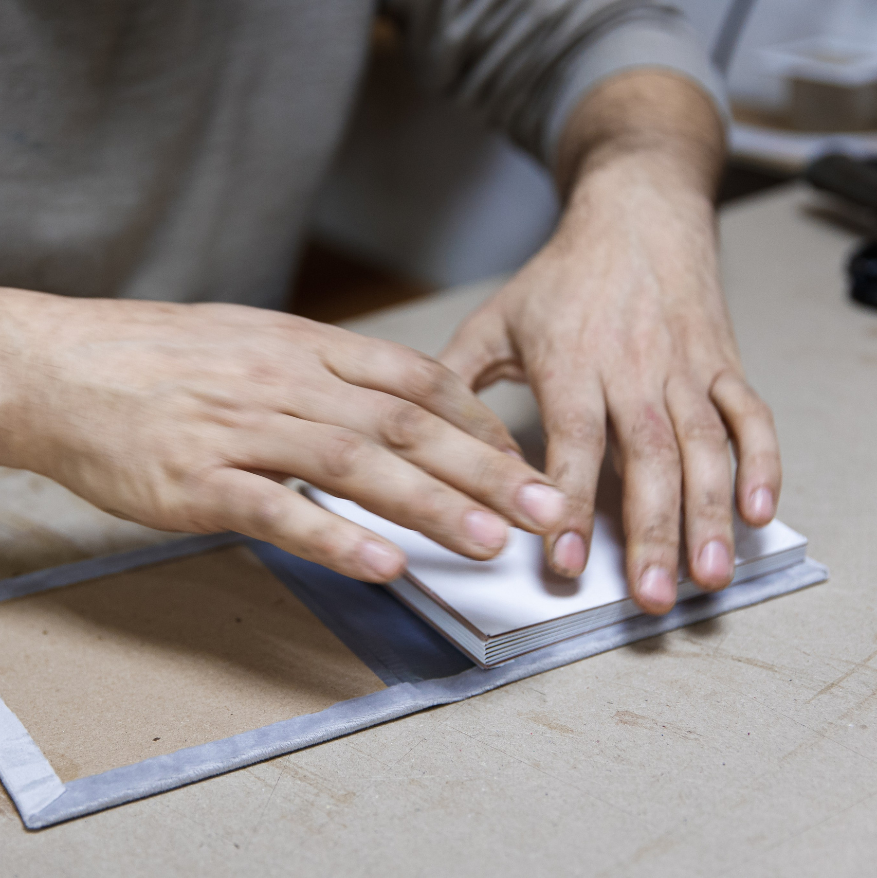 Мастер за работой: ручная сборка фотоальбома, проклейка и создание кожаного переплета.